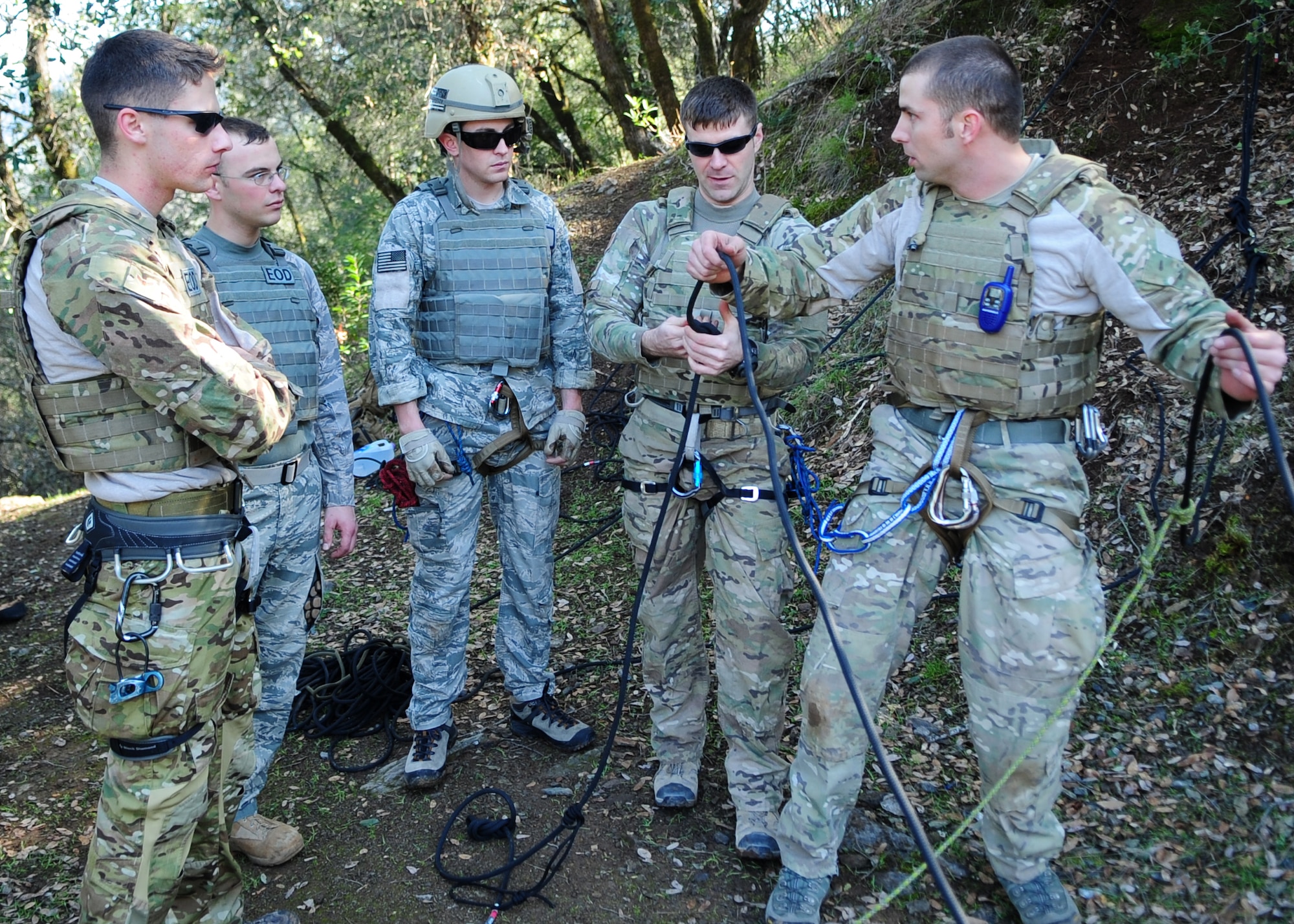 (Right) Staff Sgt. Scott Love, 9th Civil Engineer Squadron explosive ordnance disposal technician, explains the gear used to repel to fellow EOD Airmen during training in Auburn, Calif., Feb. 17, 2012. Love was preparing to repel down a more than 200 foot cliff with a simulated casualty. (U.S. Air Force photo by Senior Airman Shawn Nickel/Released)