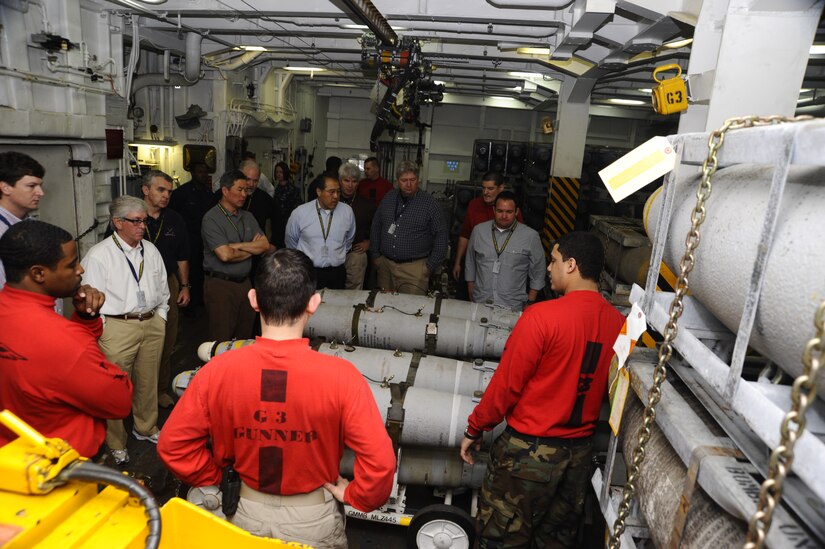 Sailors, who work on an aircraft carrier’s bomb storage deck, explain their daily duties to 12 community leaders, Jan 16, 2012, during a Distinguished Visitors Embark aboard the USS Enterprise (CVN 65). The ship was 75 miles of the coast of Florida and was conducting pre-deployment exercises. The Navy’s DV Embark program is designed to increase awareness of the Navy's mission by selecting community leaders to share their experiences with the largest possible audience. (Courtesy photo) 