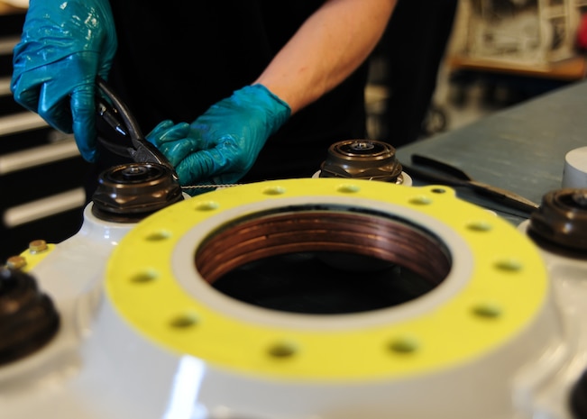 Keith Antonacci secures safety wire to a C-17 Globemaster III's brakes during build up at Joint Base Charleston - Air Base Feb. 23. The safety wire is used to secure the brake parts. Antonacci is a 437th Maintenance Squadron hydraulic technician, 437th Airlift Wing. (U.S. Air Force photo/Staff Sgt. Katie Gieratz)
