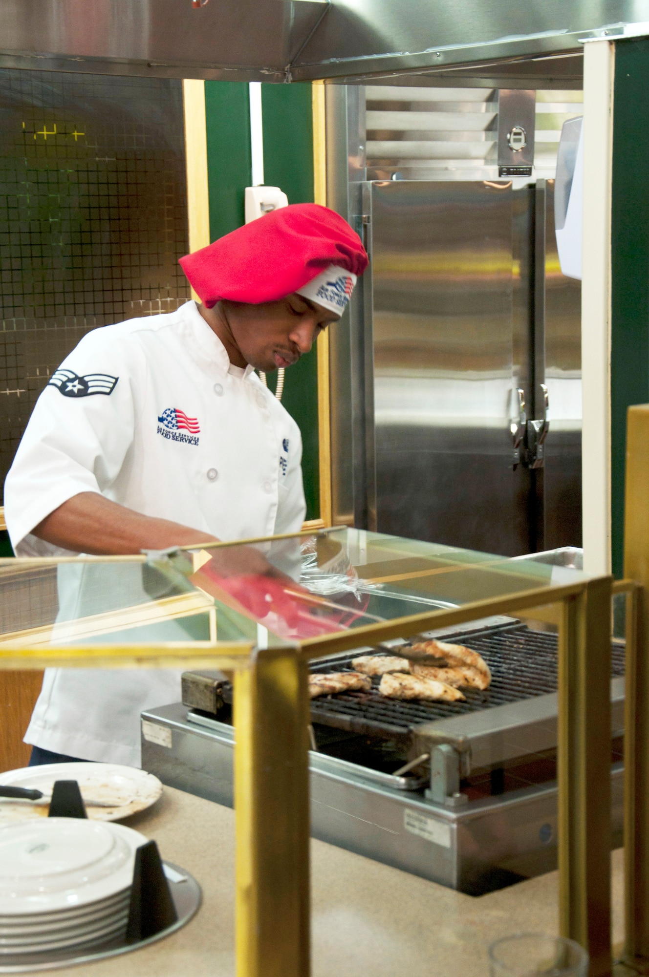 Senior Airman Keelan Pierre, 90th Force Support Squadron food service specialist, prepares grilled chicken for customers Feb. 20 in the Chadwell Dining Facility here. (U.S. Air Force photo/Airman Jason Wiese)
