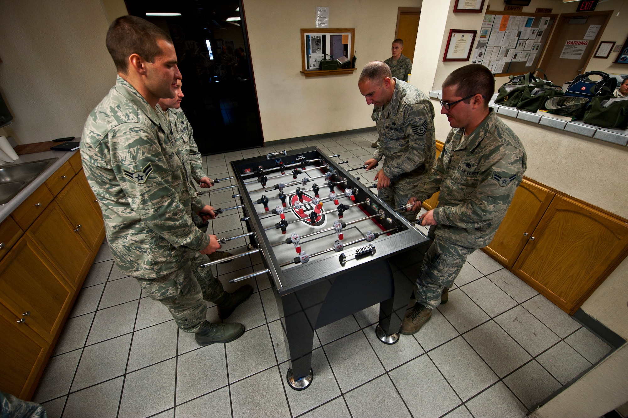 Airmen from the 99th Logistics Readiness Squadron play fooz-ball while waiting for technical orders Feb. 23rd, 2012 at Nellis Air Force Base, Nev. The Fuels Management Flight, responsible for fueling all aircraft at Nellis AFB, accomplishes its mission daily regardless of condition or number of airframes serviced. (U.S. Air Force photo by Senior Airman Brett Clashman)