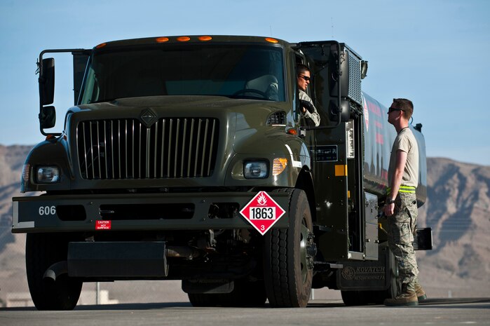 Airman 1st Class Michael Camarillo, fuels distribution apprentice, 99th Logistics Readiness Squadron, speaks to Senior Airman Mike Waters, fuels distribution apprentice, 75th LRS at Hill Air Force Base, Utah Feb. 23rd, 2012 at Nellis Air Force Base, Nev. The Fuels Management Flight, responsible for fueling all aircraft at Nellis AFB, accomplishes its mission daily regardless of condition or number of airframes serviced. (U.S. Air Force photo by Senior Airman Brett Clashman)