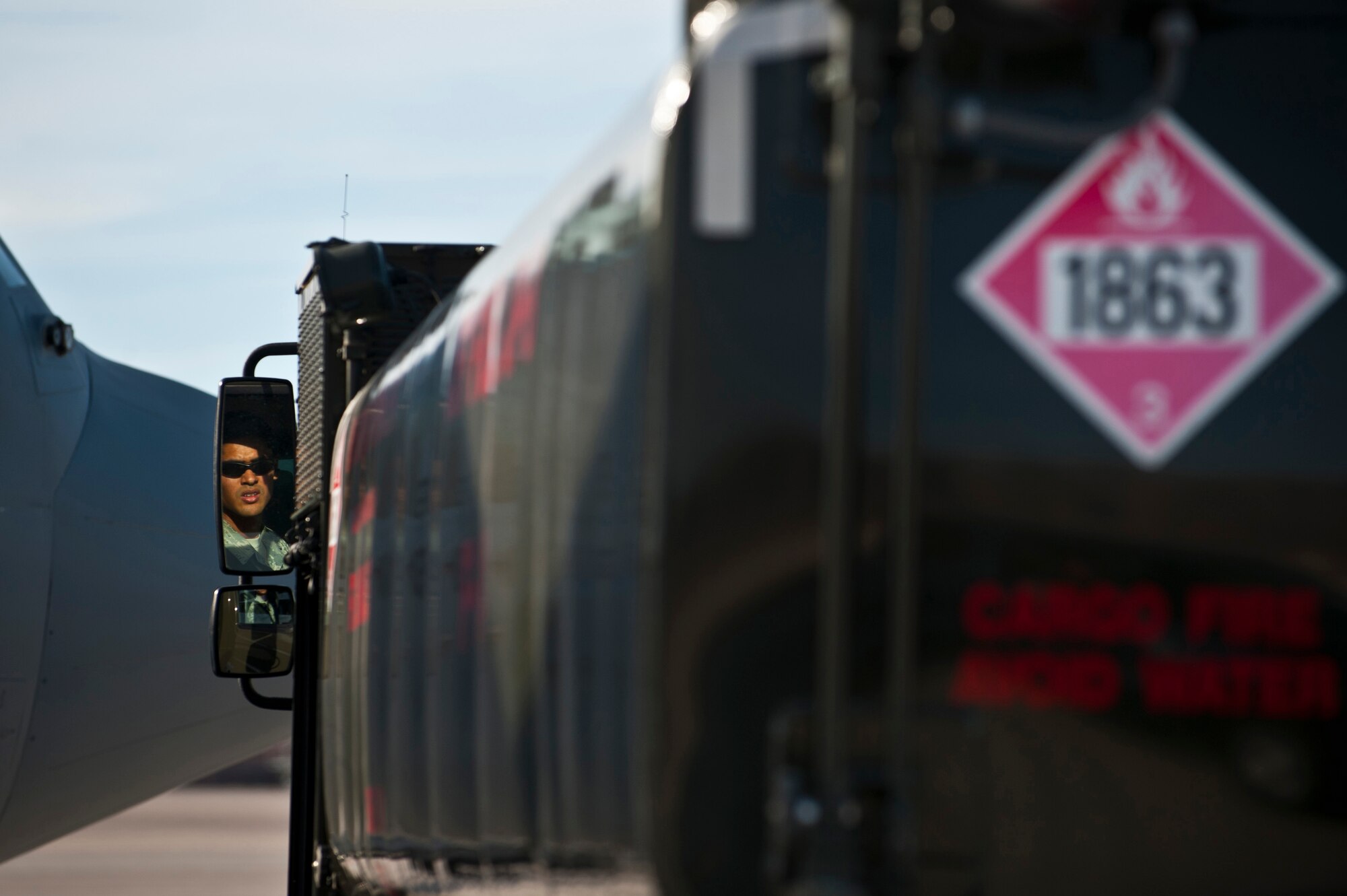 Airman 1st Class Michael Camarillo, fuels distribution apprentice, 99th Logistics Readiness Squadron, checks the rear view mirror Feb. 23rd, 2012 at Nellis Air Force Base, Nev. The Fuels Management Flight, responsible for fueling all aircraft at Nellis AFB, accomplishes its mission daily regardless of condition or number of airframes serviced. (U.S. Air Force photo by Senior Airman Brett Clashman)