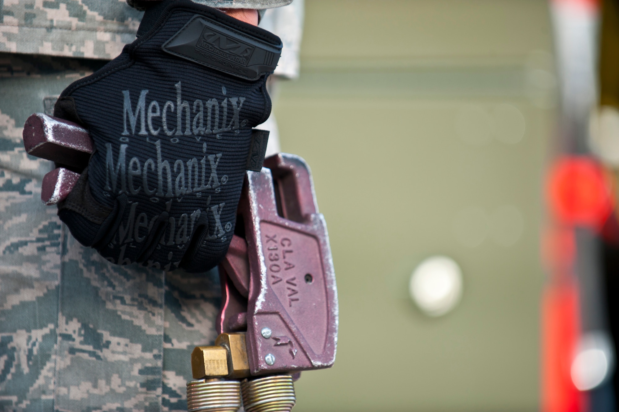 Airman 1st Class Michael Camarillo, fuels distribution apprentice, 99th Logistics Readiness Squadron, holds a gas release handle Feb. 23rd, 2012 at Nellis Air Force Base, Nev. The Fuels Management Flight, responsible for fueling all aircraft at Nellis AFB, accomplishes its mission daily regardless of condition or number of airframes serviced. (U.S. Air Force photo by Senior Airman Brett Clashman)