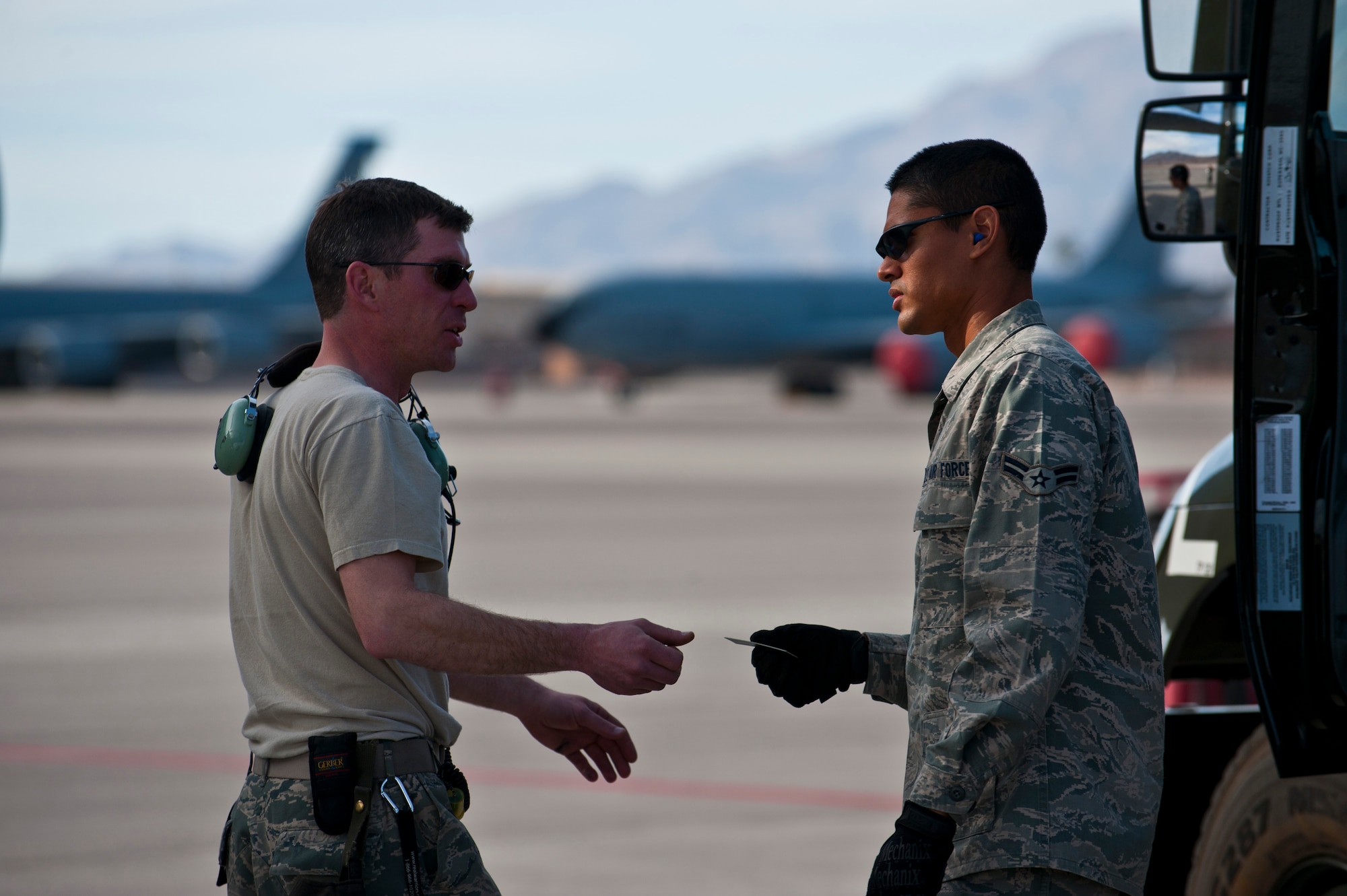 Tech. Sgt. Kevin Hoke, crew chief, 187th Airlift Squadron, Wyoming Air National Guard, gives a controlled spending card to Airman 1st Class Michael Camarillo, fuels distribution apprentice, 99th Logistics Readiness Squadron, Feb. 23rd, 2012 at Nellis Air Force Base, Nev. The Fuels Management Flight, responsible for fueling all aircraft at Nellis AFB, accomplishes its mission daily regardless of condition or number of airframes serviced. (U.S. Air Force photo by Senior Airman Brett Clashman)