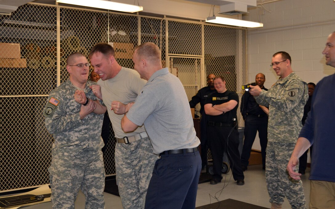 U.S. Army Sgt. Nathaniel Lesperance, right, 221st Military Police Detachment policeman, employs a TASER on Staff Sgt. Kyle Daun, left-center, 221st MPD policeman, during voluntary exposure training at Fort Eustis, Va. Feb. 17, 2012.  The 221st MPD and 733rd Security Forces Squadron conducted TASER training in order to certify their personnel on the X26 TASER. (Courtesy photo)