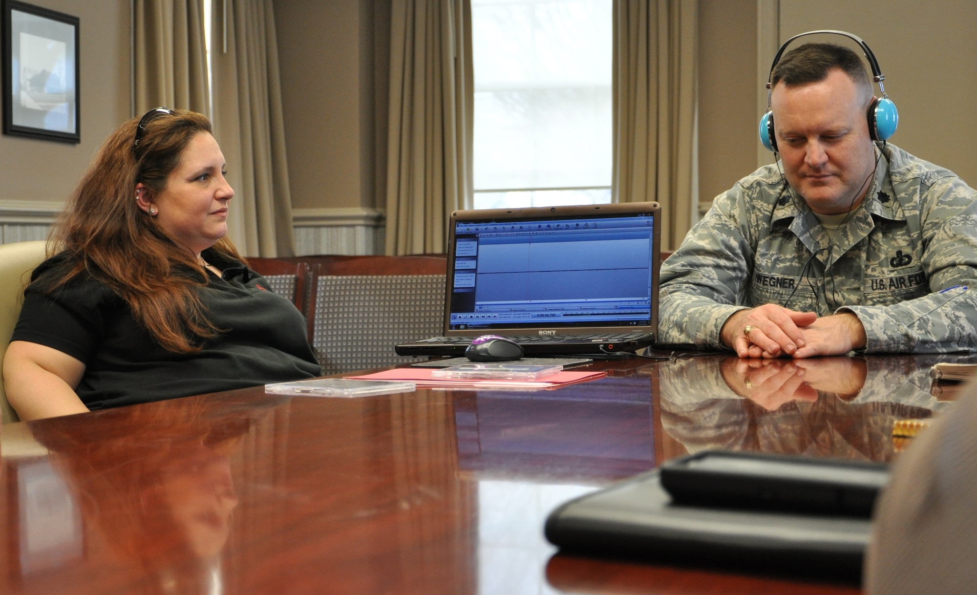 Lt. Col. Christopher Wegner, 633rd Contracting Squadron commander, right, reviews audio recordings  with Beth Massie, an investigator with R.T.L. Paranormal, in the squadron's conference room Feb. 24, 2012. Among the evidence collected during R.T.L.'s investigation of the 633rd CONS building recently were nearly 30 instances of what investigators dubbed electronic voice phenomena, theorized to be paranormal in nature. (U.S. Air Force photo by Senior Airman Jason J. Brown/Released)