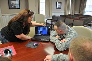 Beth Massie, left, an investigator with R.T.L. Paranormal, reviews video footage with Lt. Col. Christopher Wegner, 633rd Contracting Squadron commander, and Chief Master Sgt. Bradley Smith, 633rd CONS superintendent, in the squadron's conference room Feb. 24, 2012. R.T.L. Paranormal investigated the 633rd CONS building, a historic farmhouse built before Langley Air Force Base was established, recently in search of evidence to support claims of paranormal activity, including apparitions and strange sounds. (U.S. Air Force photo by Senior Airman Jason J. Brown/Released)