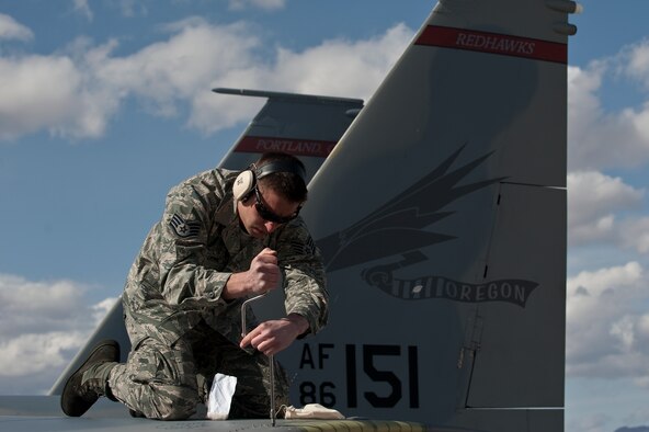 U.S. Air Force Staff Sgt. Matthew Shelburne, crew chief, 142nd Aircraft Maintenance Squadron, Portland Air National Guard, conducts maintenance on an F-15C Eagle during Red Flag 12-3 Feb. 28, 2012, at Nellis Air Force Base, Nev. Red Flag is a realistic air-to-air combat training exercise involving the air forces of the United States and its allies. (U.S. Air Force photo by Staff Sgt. Christopher Hubenthal) 