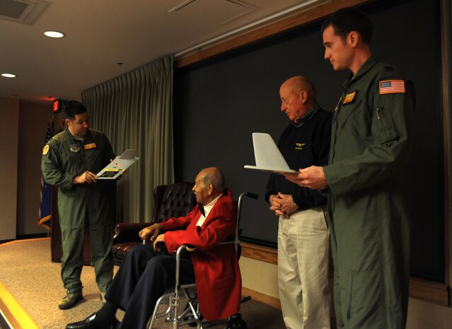 Captains Joshua Pugliese and Benjamin Smith present Tuskegee Airman Eddie Gibson and Retired Rear Adm. James Flatley with a "T Tail" memento at the 16th Airlift Squadron, 437th Airlift Wing deployment dinner at Joint Base Charleston - Air Base Feb. 16. More than 130 Airmen from the 16th AS deployed Feb. 24 to operate as part of the 816th Expeditionary Airlift Squadron. The 816th EAS supports intra-theater airlift, airdrop and aero-medical evacuation missions. Pugliese and Smith are from the 16th AS. Gibson served in the Army Air Corps as a bombardier-navigator, logged 2,300 flight hours and was awarded the Congressional Gold Medal for heroism. Flatley is the South Carolina Patriots Point Naval and Maritime Museum chief executive officer. During his career as a naval aviator he earned the Air Medal and Distinguished Flying Cross. (U.S. Air Force photo/Airman 1st Class Ashlee Galloway)