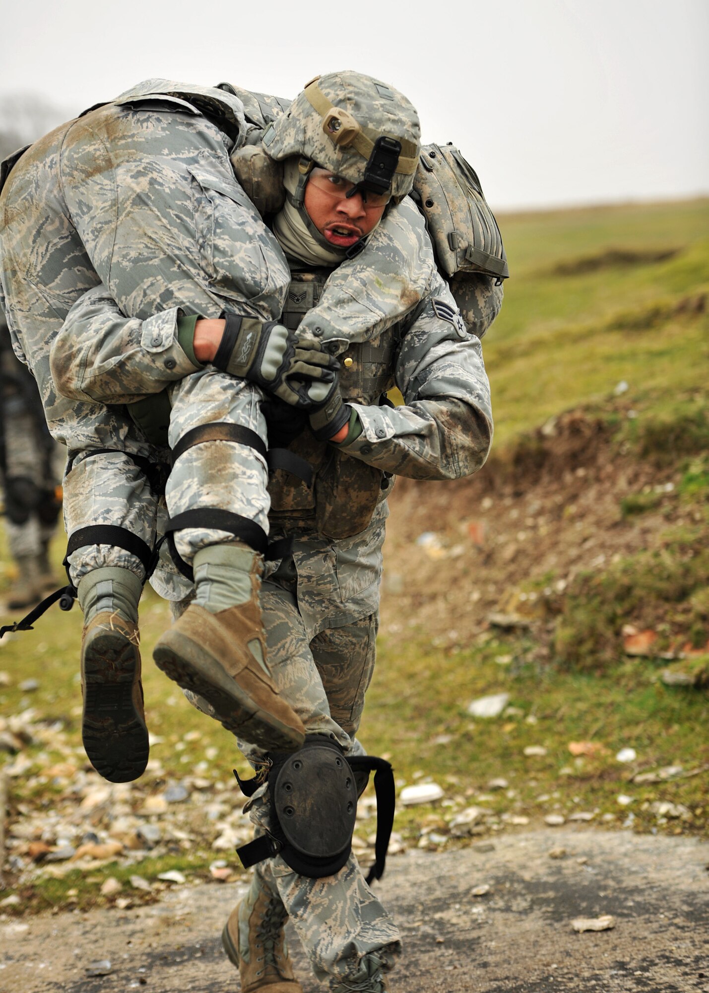 NORFOLK, England – Senior Airman Dominique Walker, 100th Security Forces Squadron, transports Senior Airman Stephanie Davis, also 100th SFS, using the fireman’s carry technique during a simulated deployment mission at Stanford Training Area, Norfolk, Feb. 28, 2012. As part of the scenario, Davis sustained a simulated mortal gunshot wound to the left leg. (U. S. Air Force photo/Senior Airman Jerilyn Quintanilla)
