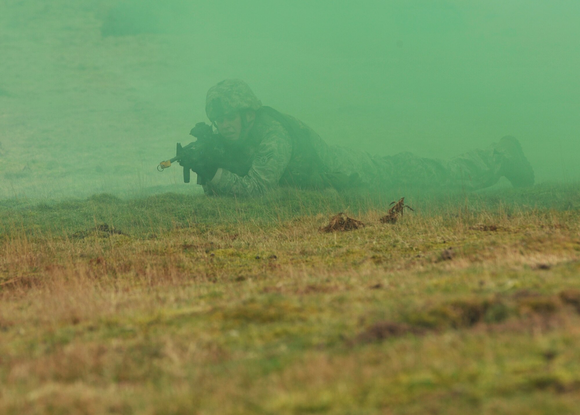 NORFOLK, England – Senior Airman Raymond Mabee, 100th Security Forces Squadron, takes cover using a smoke screen during a simulated deployment mission at Stanford Training Area, Norfolk, Feb. 28, 2012. Twenty-six Airmen from the 100th SFS gained hands-on training which included daytime and nighttime operations. (U.S. Air Force photo/Senior Airman Jerilyn Quintanilla)