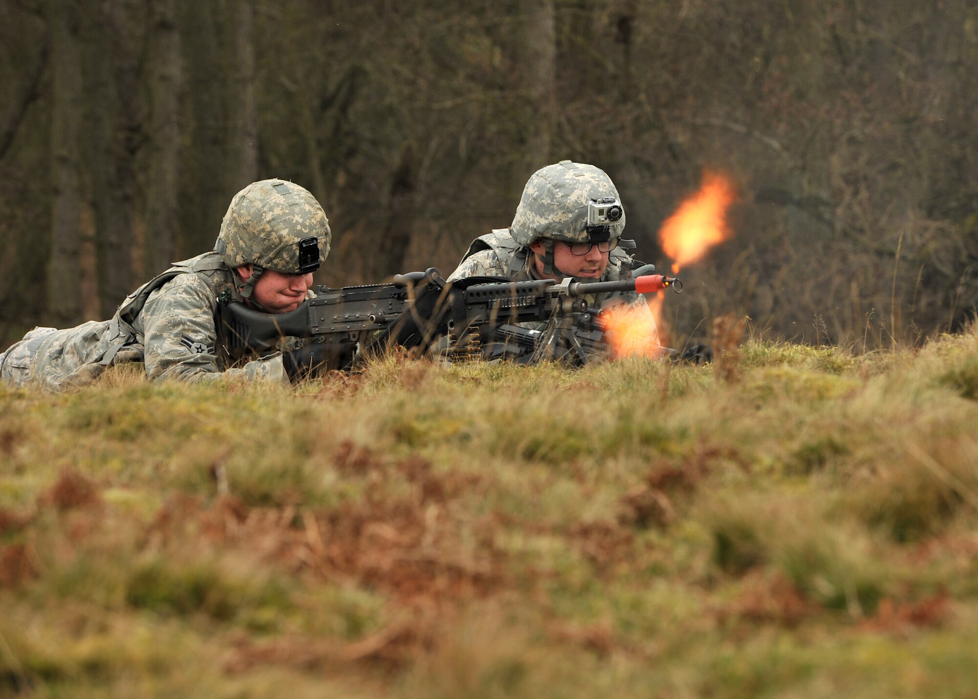 NORFOLK, England – Airman 1st Class Marcus Crawford, (left) 100th Security Forces Squadron, fires an M-240 machine gun trainer weapon during a simulated deployment mission at Stanford Training Area, Norfolk, Feb. 28, 2012. The mission required the 13-man squad to navigate their way through STANTA and engage in enemy contact. They also practiced basic combat skills and self-aid buddy care. (U.S. Air Force photo/Senior Airman Jerilyn Quintanilla)