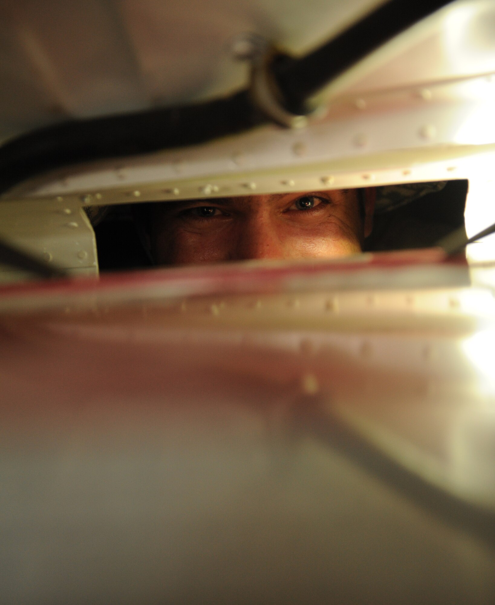 SOUTHWEST ASIA – Senior Airman Andy Schmitz, 746th Expeditionary Aircraft Maintenance Unit electrical and environmental systems specialist and native of Minneapolis, looks through a battery compartment inside the front nose landing gear of a C-130H3 Hercules during a home station check here Feb. 28, 2012. Some checks require the Airmen to get into some uncomfortable spots in order to get the job done. (U.S. Air Force photo/Staff Sgt. Nathanael Callon)