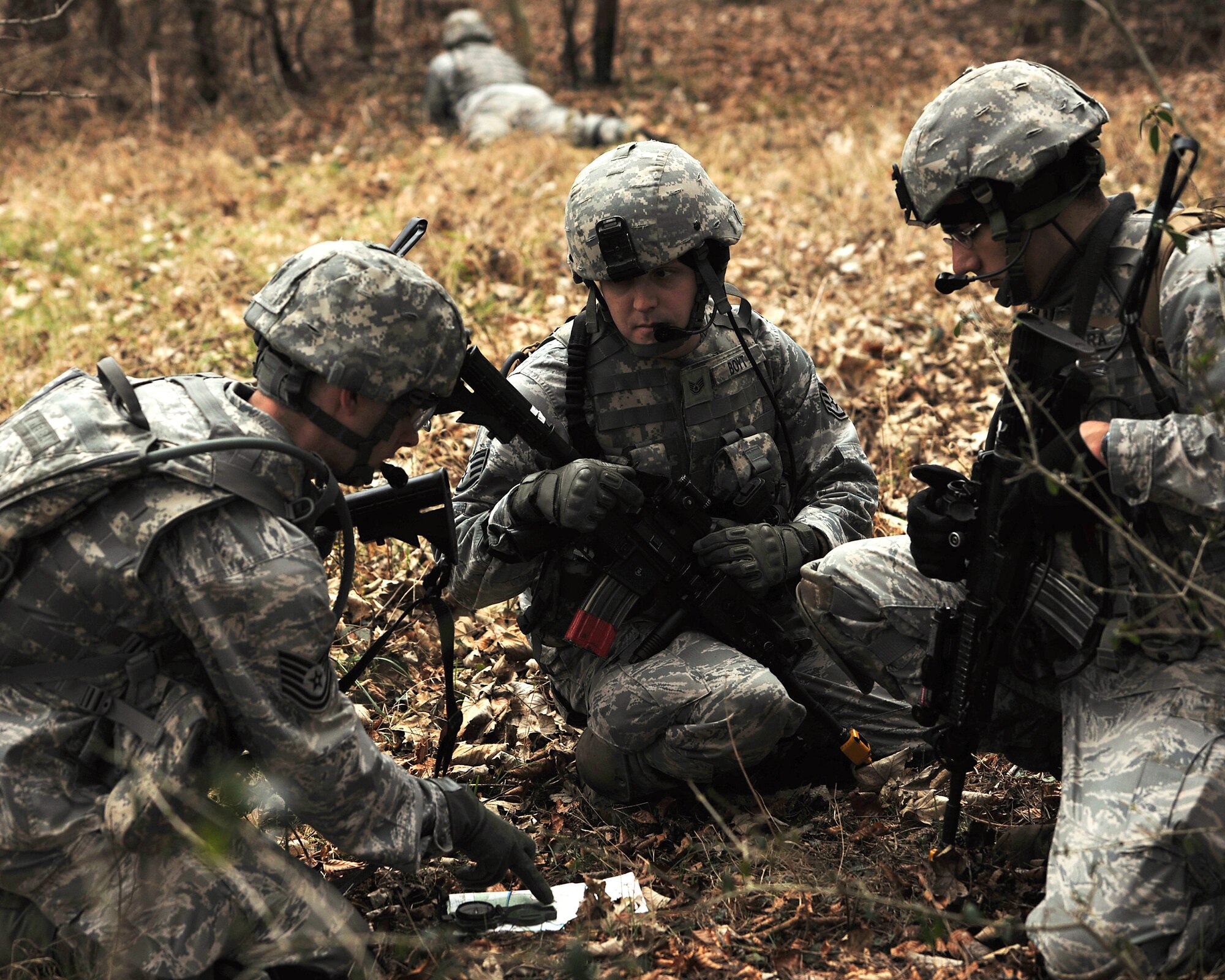 NORFOLK, England – (From left) Tech. Sgt. Brian Stokes, Staff Sgt. Houston Boyt and Staff Sgt. Gilbert Herrera, all 100th Security Forces Airmen, perform a map and compass check during a simulated deployment mission at Stanford Training Area, Norfolk, Feb. 28, 2012. The group performed periodic map and compass checks to ensure their position and route in pursuit of the mission objective. (U.S. Air Force photo/ Senior Airman Jerilyn Quintanilla)