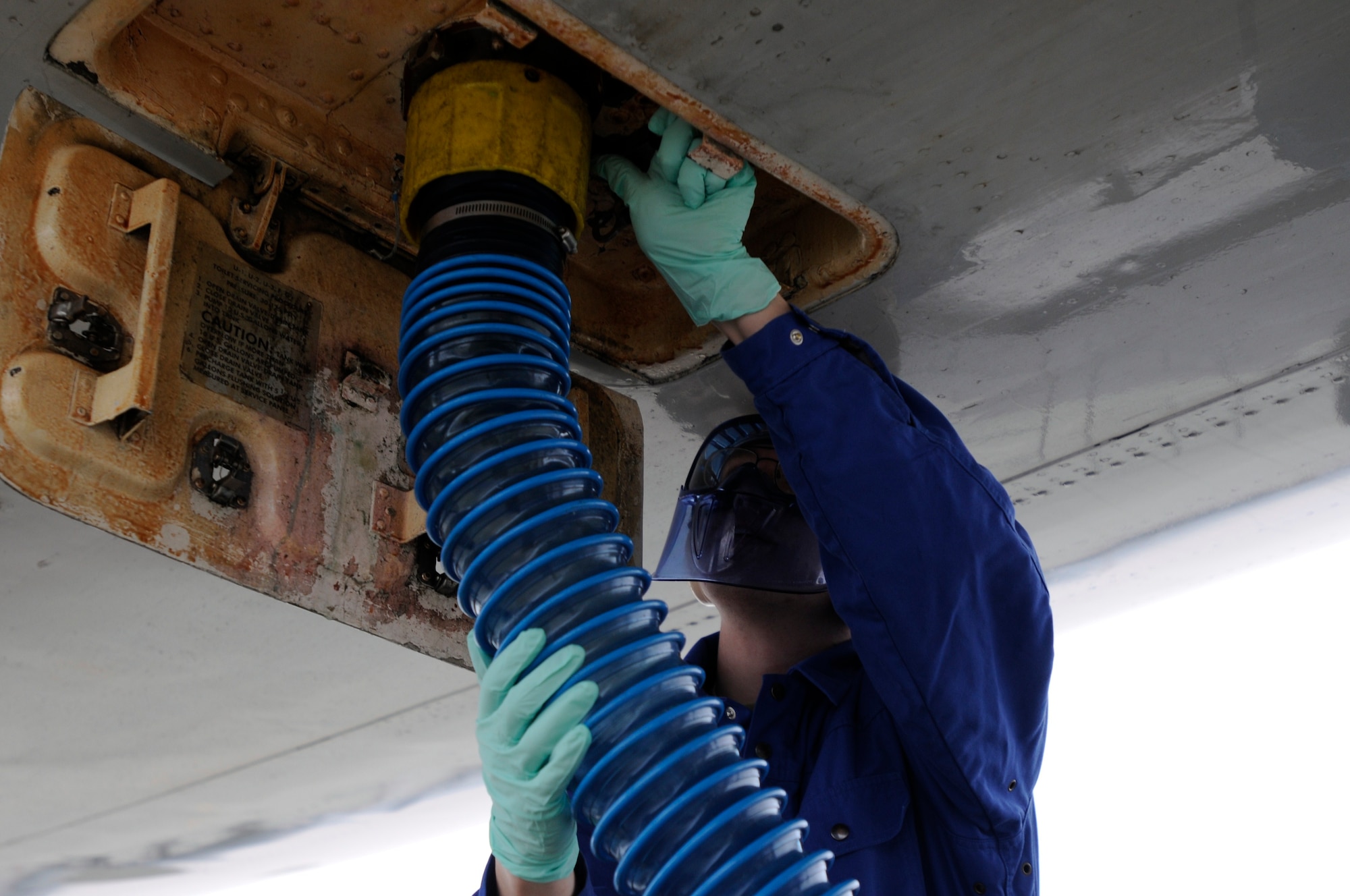 Airman 1st Class Evan Hughes, 721st Aerial Port Squadron fleet services specialist, begins draining the lavatory tanks of a Boeing 747 at Ramstein Air Base, Germany, Feb. 23, 2012. This process is accomplished on every aircraft in transit through Ramstein ensuring that every plane is cleaned prior to taking off again. (U.S. Air Force photo by Airman 1st Class Trevor Rhynes.)