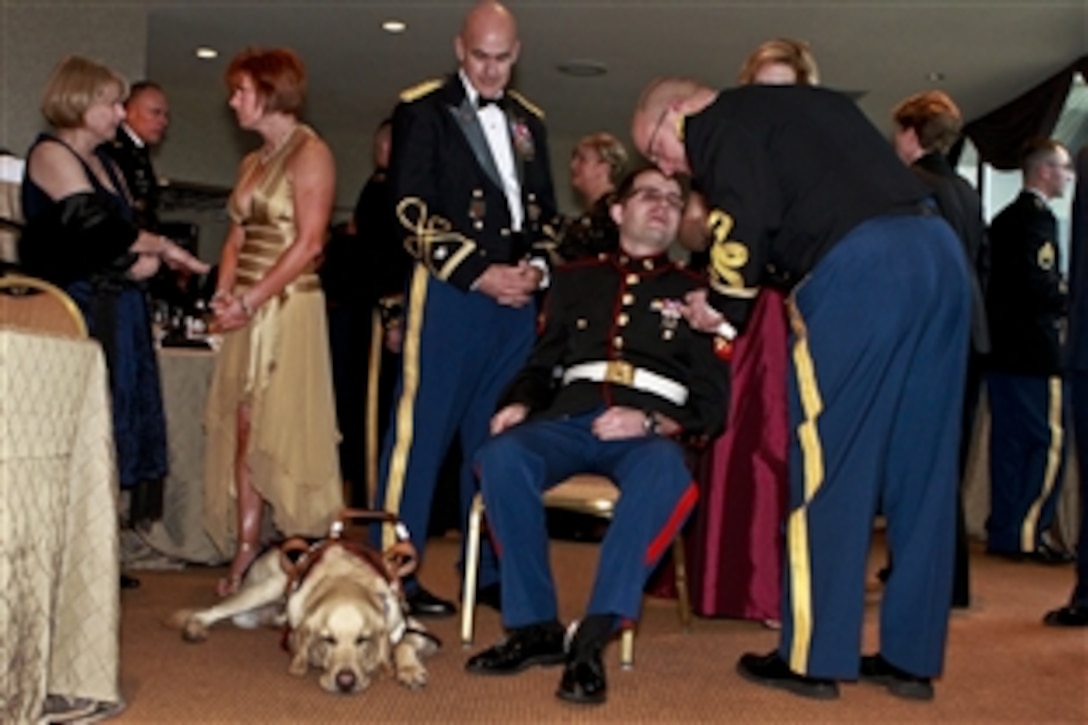 Marine Corps Cpl. Steven Schulz, an Iraq War veteran who relies on Sonny, his seeing-eye dog, talks with friends at a reception to honor Iraq War veterans in Crystal City, Va., Feb. 29, 2012. Schulz, who did two tours in Iraq in 2004 and 2005, lost an eye while serving in Iraq. About 80 Iraw War veterans attended the reception before heading to the White House to attend a dinner hosted by President Barack Obama in their honor.
