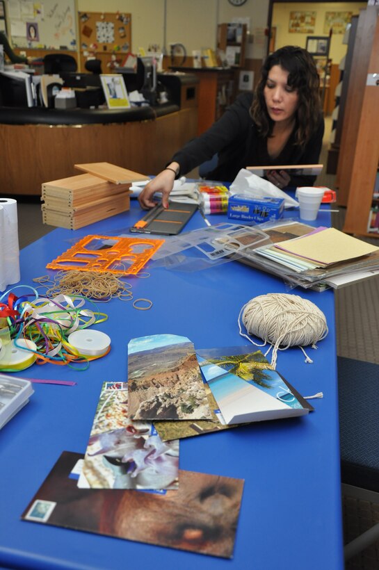 Leanah Alvarez, a library technician at McTureous Hall aboard Marine Corps Logistics Base Barstow creates stationary from old magazines during a Crafting for a Cause meeting held Feb. 16 at the base library. During the day, participants with Crafting for a Cause can use resources provided by the library to construct new projects from lesser items, often deemed "junk."