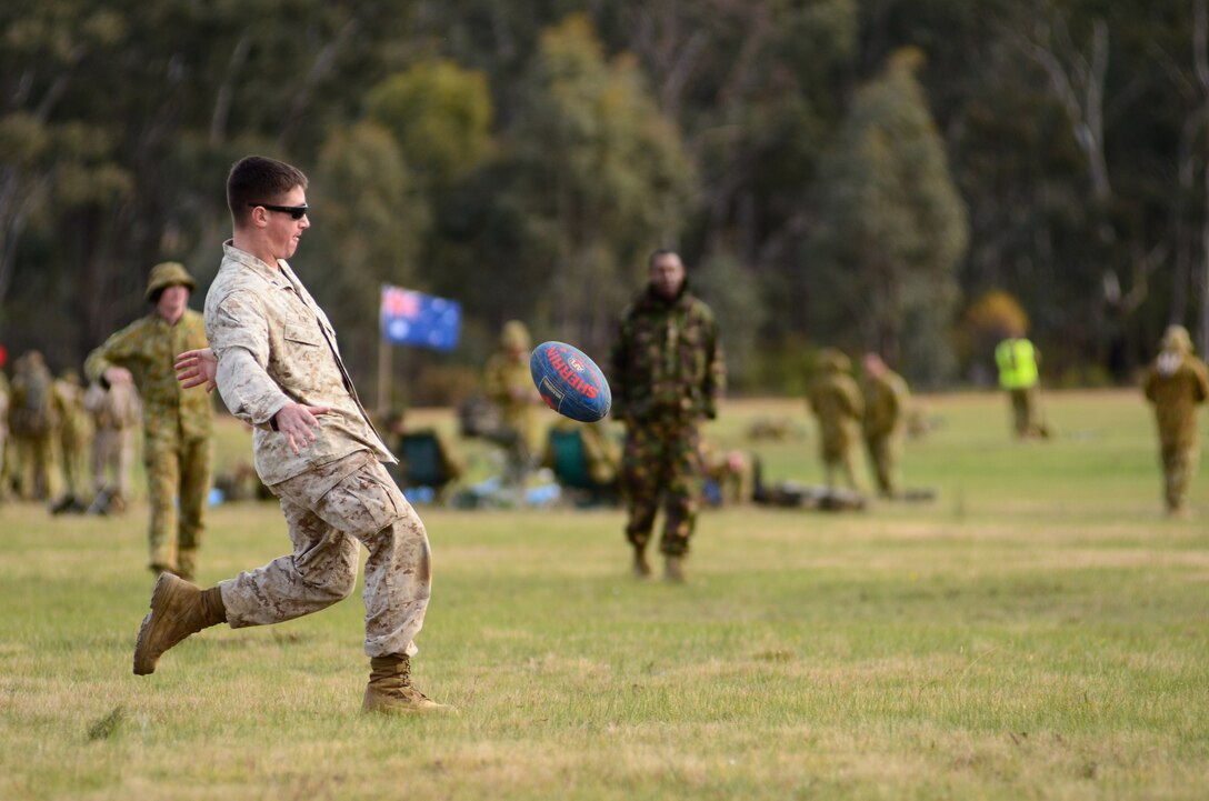 PUCKAPUNYAL, Australia-Cpl. Max King, mortarman, 3rd Battalion, 3rd Marine Regiment, 3rd Marine Division, III Marine Expeditionary Force, kicks an Australian rules football here May 14 during the 2011 Australian Army Skill at Arms Meeting (AASAM). King was playing a game with Australian and Kiwi soldiers. The week-long meeting pit military representatives from partner nations in competition through a series of grueling combat marksmanship events. Represented nations include Canada, France (French Forces New Caledonia), Indonesia, Timor Leste, Brunei, Netherlands, U.S., Papua New Guinea, New Zealand, Singapore, Malaysia, Thailand as well as a contingent of Japanese observers. (U.S. Marine Corps Photo by Lance Cpl. Mark W. Stroud/Released)