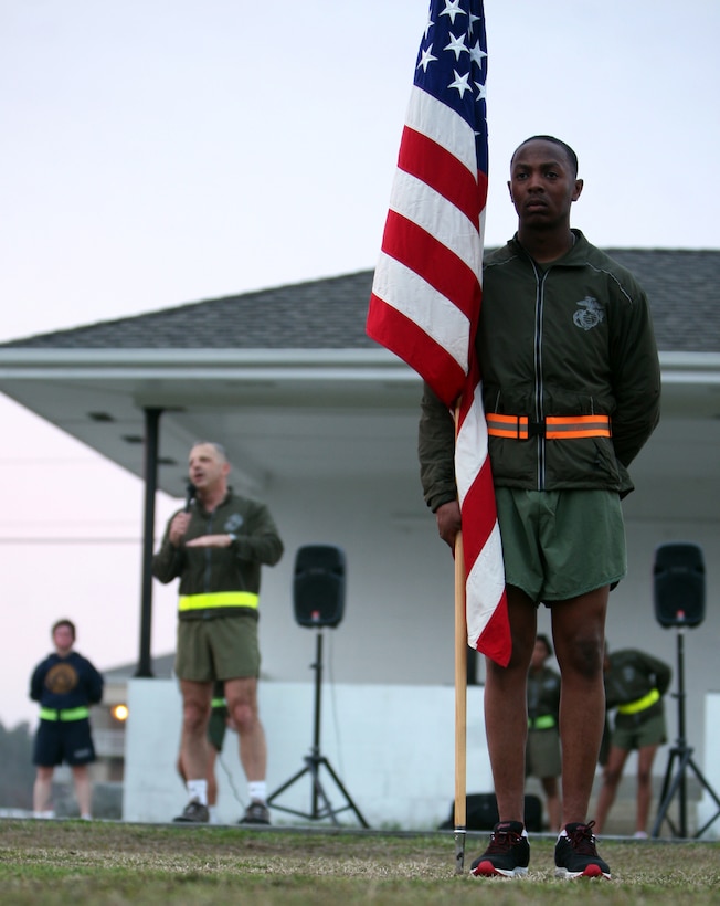 Sgt. Wade McKinley, the 2nd Marine Logistics Group color sergeant, holds the American flag while Maj. Gen. Michael G. Dana, the 2nd MLG commanding general, speaks to more than 700 Marines and sailors after a motivational run aboard Camp Lejeune, N.C., Feb. 24, 2012. After the run, Dana thanked the Marines and sailors for their hard work throughout the past year. 