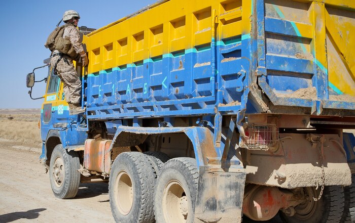 Capt. Jesse Hills, the team leader of Team 3, Civil Affairs Detachment 11-2, climbs a dump truck to inspect the contents during a patrol in Khan Neshin, Afghanistan, Feb. 29, 2012. The truck was carrying gravel to place over a culvert in the road. Afghans are currently paving a road in Khan Neshin, equipped with culverts to allow canals to pass though to the surrounding farms. The road is a civil affairs –initiated project to help the locals build an infrastructure on their own. Hills is a 28-year-old native of Terre Haute, Ind., who served as an intelligence officer with 11th Marine Regiment before detaching to the civil affairs team.