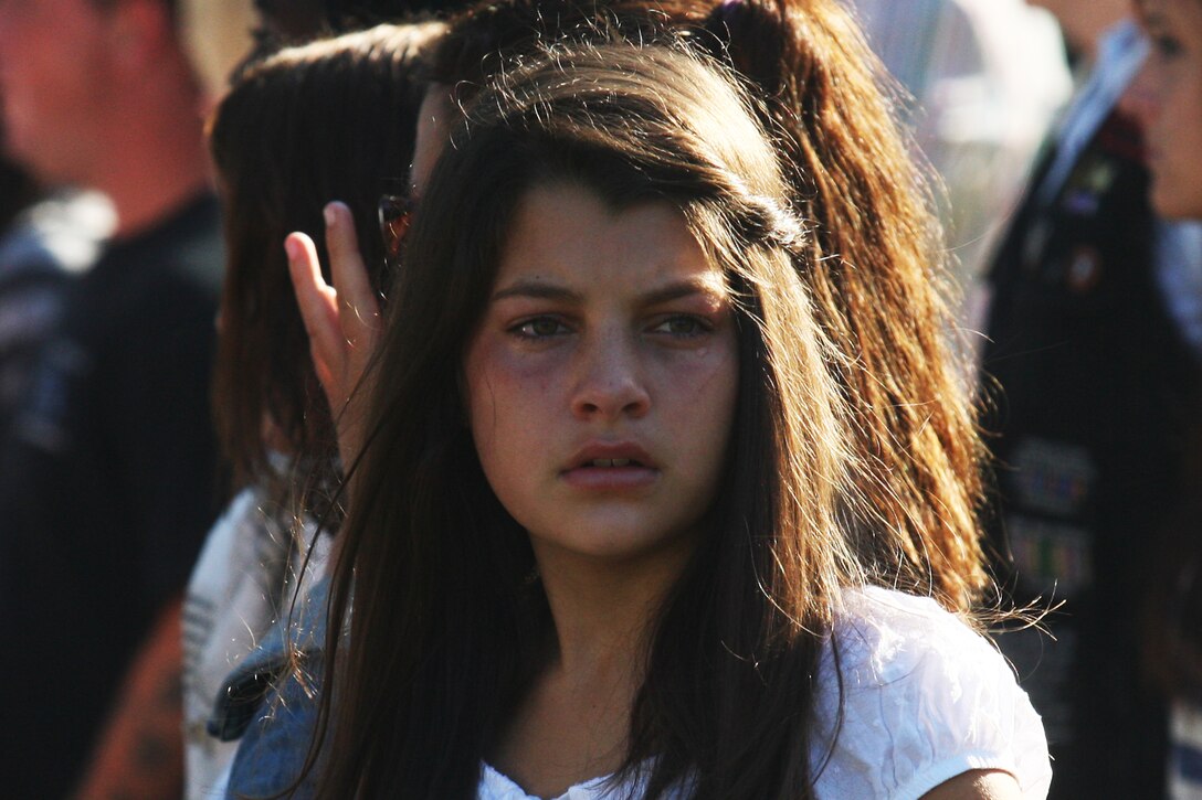 A young girl reacts to the Patriot Day 2011 memorial ceremony marking the 10th anniversary of the Sept. 11, 2011 terrorist attacks, at the Memorial Beam in Lejeune Memorial Gardens, Sept. 11. A decade following the al-Qaeda attacks on the World Trade Center, the Pentagon and a failed attempt in Shanksville, Pa., American citizens come together to remember and memorialize those lost on that tragic day as well as those who lost their lives in the following War on Terror.