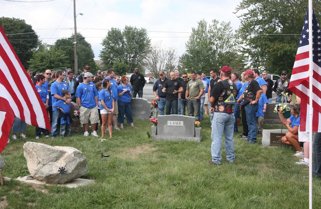 Family and friends stand around Cpl. John C. Bishop’s tombstone September 10, 2011, while sharing stories and experiences with each other.  Bishop was killed-in-action one year ago while serving as an infantryman with 2nd Battalion, 9th Regiment, 2nd Marine Division, in Marjah, Afghanistan. (U.S. Marine Corps photo by Pfc. Franklin E. Mercado)