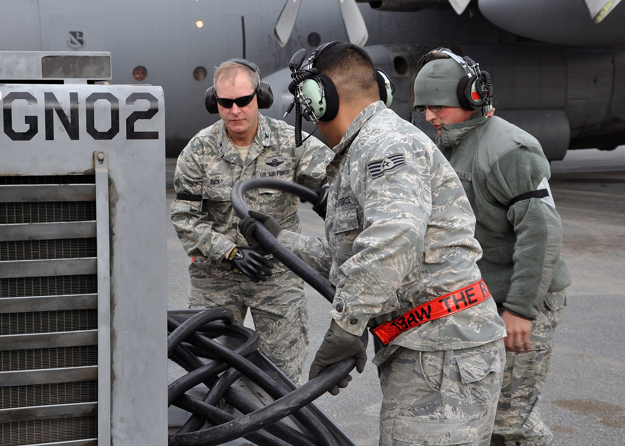 SOUTHWEST ASIA -- Col. Michael Zick, 386th Air Expeditionary Wing commander, assists Senior Airman Mathew Schmidt (right) and Staff Sgt. Julian Pacheco (center), 386th Expeditionary Aircraft Maintenance Squadron crew chiefs, disconnect a generator from a C-130 Hercules before its first flight of the new year, Jan. 1, 2012.  Zick volunteered to be an honorary crew chief for 2012’s initial sortie, pulling parking chalks and marshalling the aircraft out of its parking spot and onto the flightline prior to takeoff. (U.S. Air Force photo/Tech. Sgt. Stacy Fowler) 