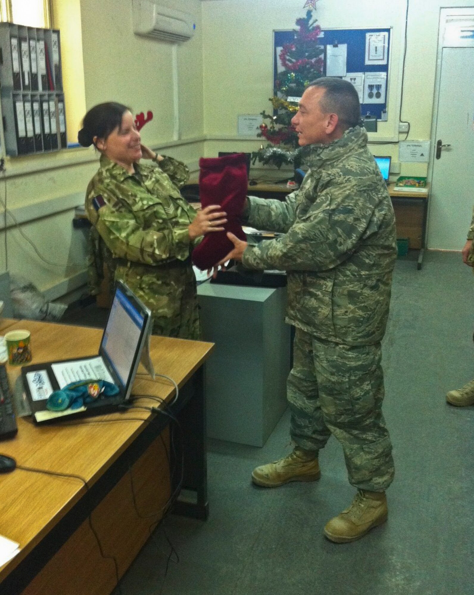 KANDAHAR AIRFIELD, Afghanistan -- From right, Chaplain (Capt.) Kevin Humphrey, a 451st Air Expeditionary Wing chaplain, gives a stocking to a Royal Air Force service member at Kandahar Airfield, Afghanistan, Dec. 21, 2011. Humphrey and his team of volunteers received more than 3,400 stockings to give to fellow Airmen and coalition partners at Kandahar. (Courtesy photo)