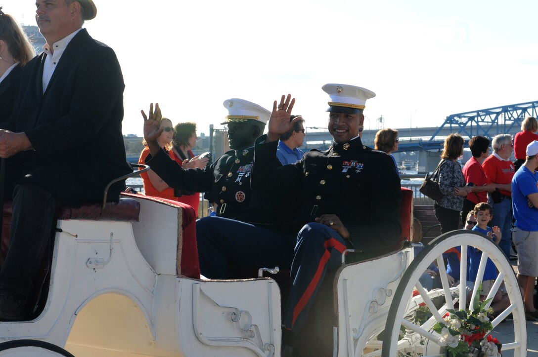 Major General Ronald Bailey (left), commanding general 1st Marine Division and Capt.  Robert Brooks, officer selection officer for Gainesville, Fla., wave to onlookers during the 2012 Gator Bowl parade in Jacksonville, Fla. December 31, 2011. Bailey and Brooks rode the lead buggy and served as the parade marshals. The Gator Bowl is an annual event that has been held continuously since 1946. Not only is it among the oldest but it is also one of the first televised football games.  The Marines have had an on-site presence for several previous Gator Bowl games and have built a strategic partnership with the committee that allows the Corps to reach large and diverse crowd of spectators. (Official USMC photo by Sgt. Michael Walters)
