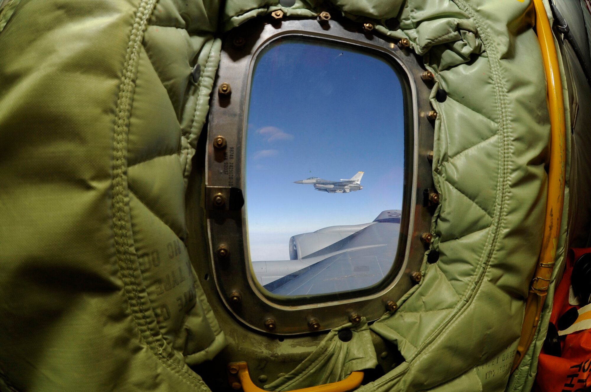 An F-16 Fighting Falcon from the 80th Fighter Squadron coasts beside a KC-135 Stratotanker of the 909th Air Refueling Squadron from Kadena Air Base, Japan, as part of a refueling training mission off the coast of the Republic of Korea, Dec. 28, 2011. (U.S. Air Force photo by Senior Airman Jessica Hines/Released)