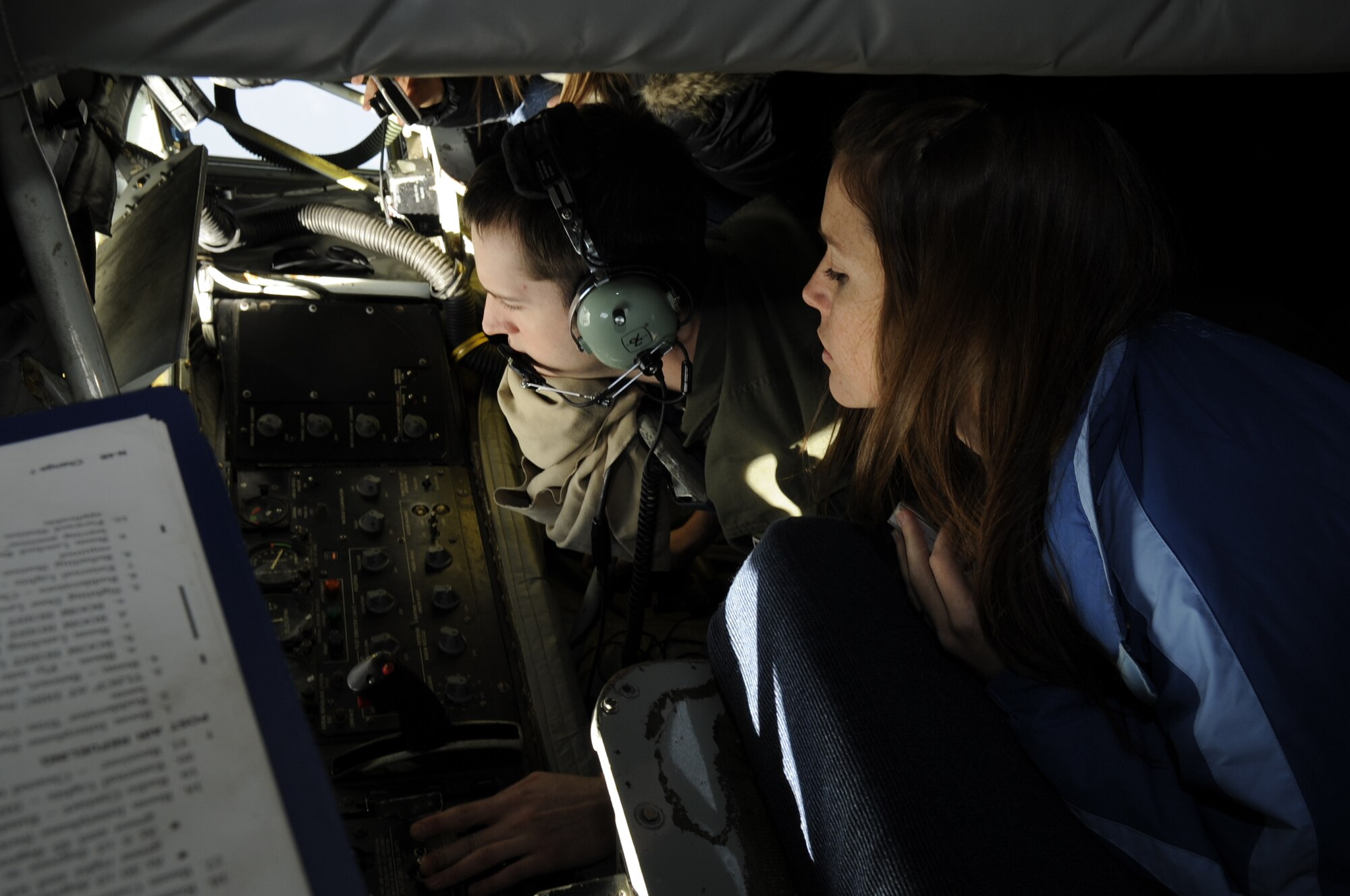 Erika Bernardo, wife of Capt. Christopher Bernardo, 80th Fighter Wing pilot, watches as Senior Airman Derek Greene, 909th Air Refueling Squadron boom operator, controls the boom during an in-flight air refueling mission off the coast of the Republic of Korea, Dec. 28, 2011. As part of a joint effort between the 80th Fighter Squadron and the 909th ARS from Kadena Air Base, Japan, military spouses visiting the Republic of Korea were given the opportunity to fly on the air refueling mission. (U.S. Air Force photo by Senior Airman Jessica Hines/Released)