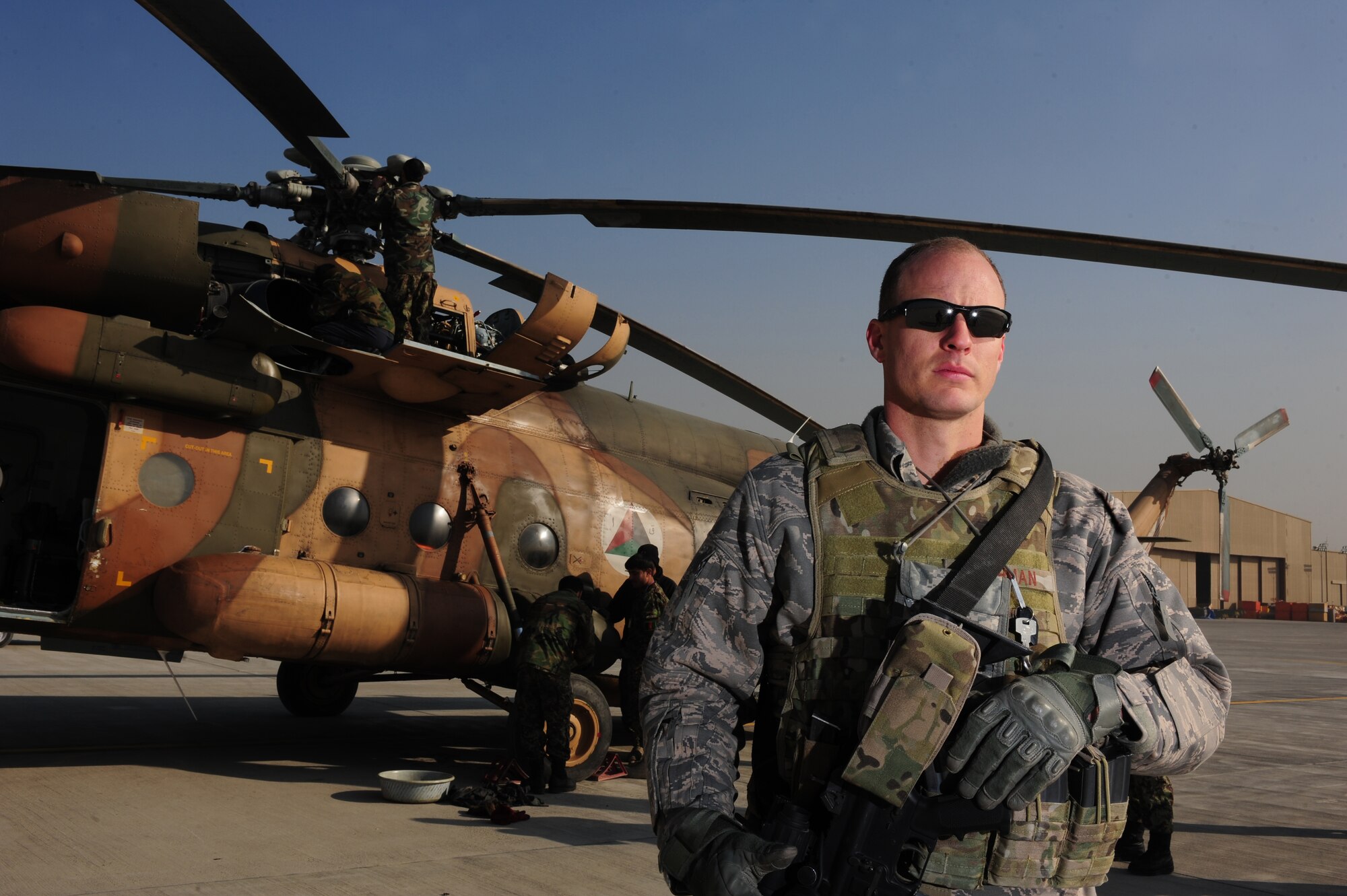 Tech. Sgt. Charles Heathman, an adviser with the 438th Air Expeditionary Wing , stands near an Afghan air force MI17 prior to receiving  a phone call from Secretary of Defense Leon Panetta New Year's Day, Jan. 1, 2012, at Kabul International Airport. Heathman was hand-picked as the Air Force representative to receive a call from Panetta. (U.S. Air Force photo by Staff Sgt. Nadine Y. Barclay)