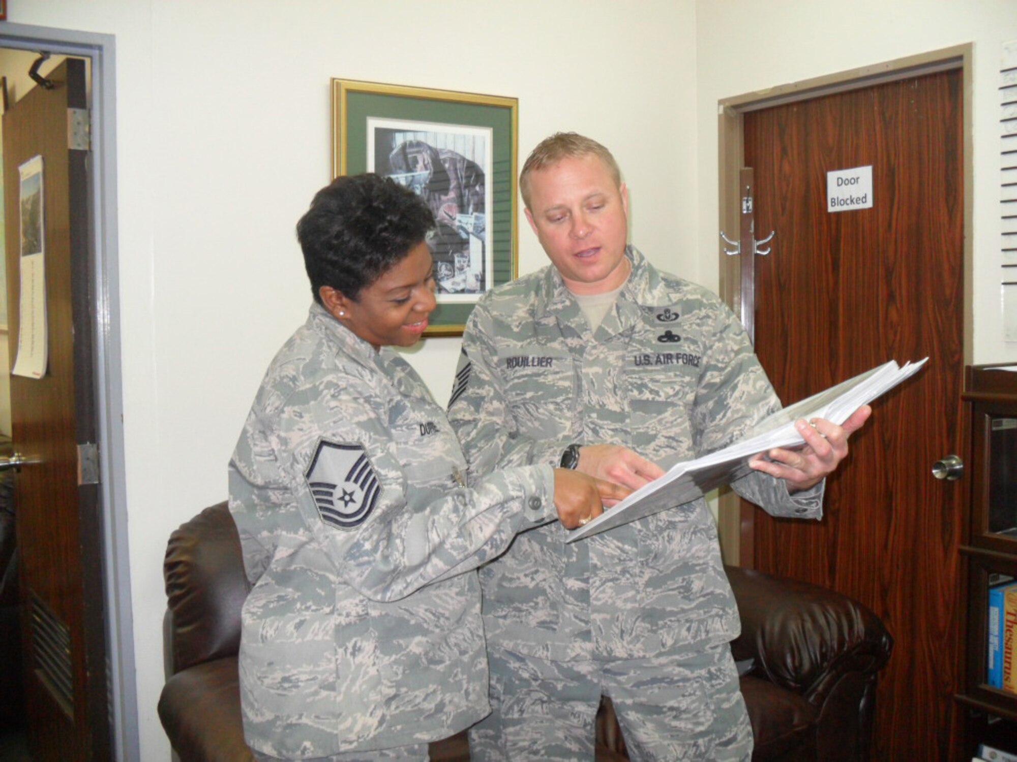 YOKOTA AIR BASE, Japan -- Shuntesia Dupree and Sean Rouillier, both master sergeants from 5th Air Force, review the daily tasking log at Yokota Air Base, Japan. Recently, Rouillier helped Dupree and her family get settled during their permanent change of station to Yokota. (Courtesy photo)