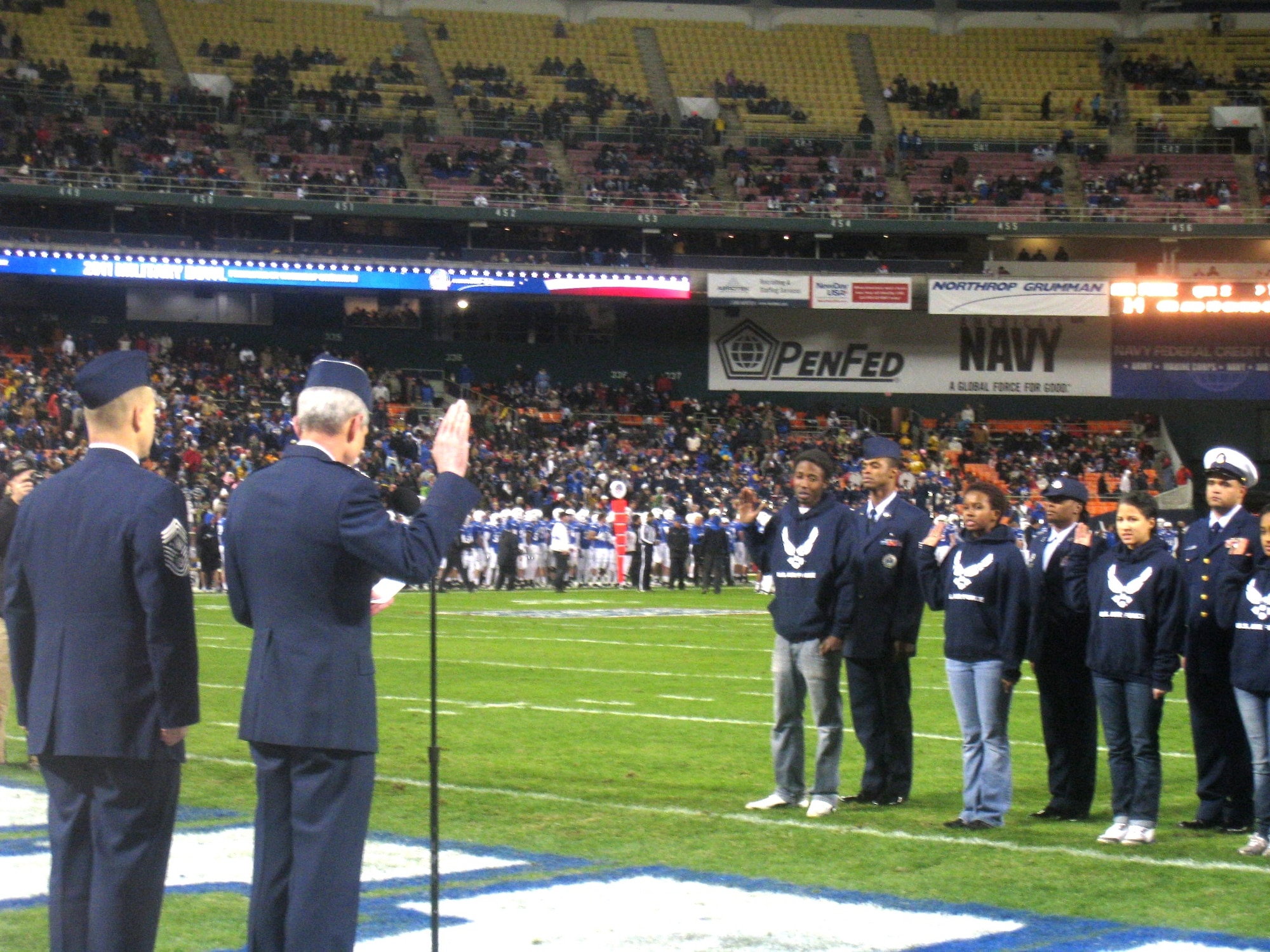 General Norton Schwartz, Air Force chief of staff, conducted a joint swear-in of eight new Air Force and Coast Guard recruits during the Military Bowl here Dec. 28. Schwartz was accompanied by the Chief Master Sgt. of the Air Force, James Roy. The new military recruits took the oath of enlistment on the field in front of 25,000 Military Bowl fans. (U.S. Air Force photo)
