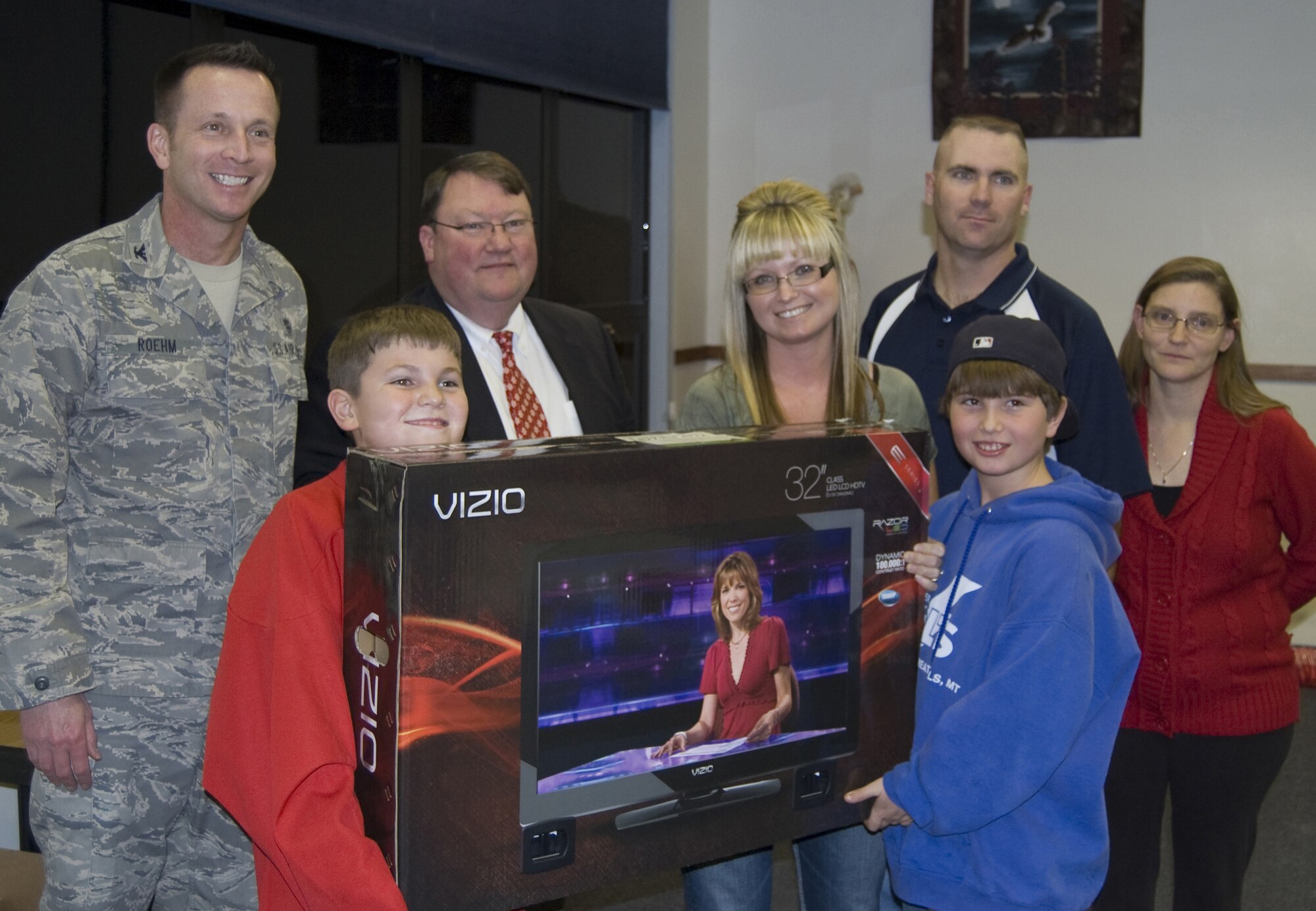 Col. Bruce Roehm, 341st Medical Group commander, and Steve Grooms, 1st Liberty Federal Credit Union, stand with the winners of a 32-inch flat-screen TV; Mindy Cronin and her sons Mark and Chris. Master Sgt. Chris Matt, 341st Maintenance Operations Squadron first sergeant, and his wife, Lynn are also pictured. Mindy is the spouse of Staff Sgt. Dallas Cronin, who is currently deployed. (U.S. Air Force courtesy photo)