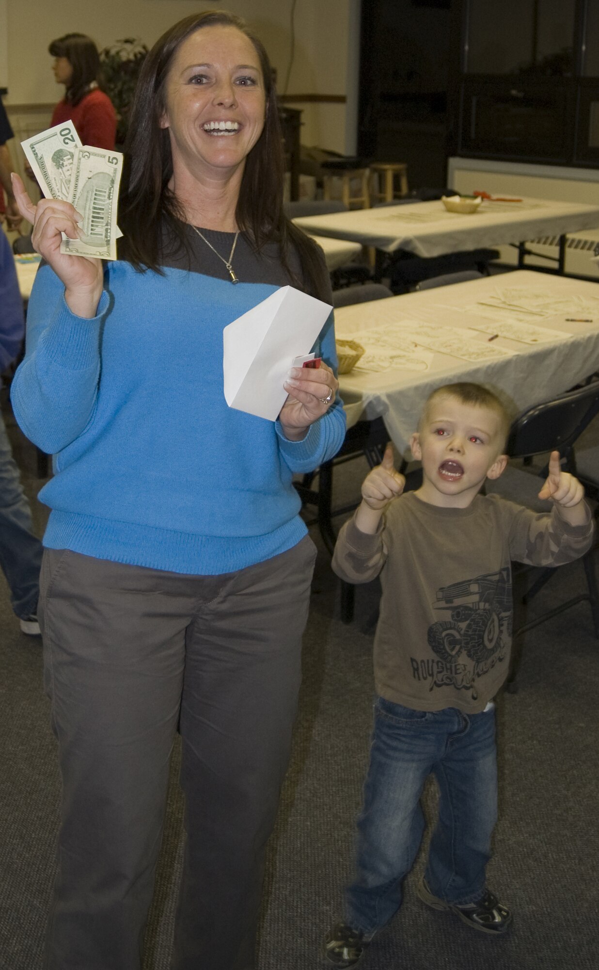 Lynn Formell and her son Edward celebrate winning $25 during the Deployed Spouses' Holiday Party Dec. 14. Lynn is the wife of Master Sgt. Anthony Formell of the 341st Missile Security Forces Squadron, who is currently deployed. (U.S. Air Force courtesy photo)