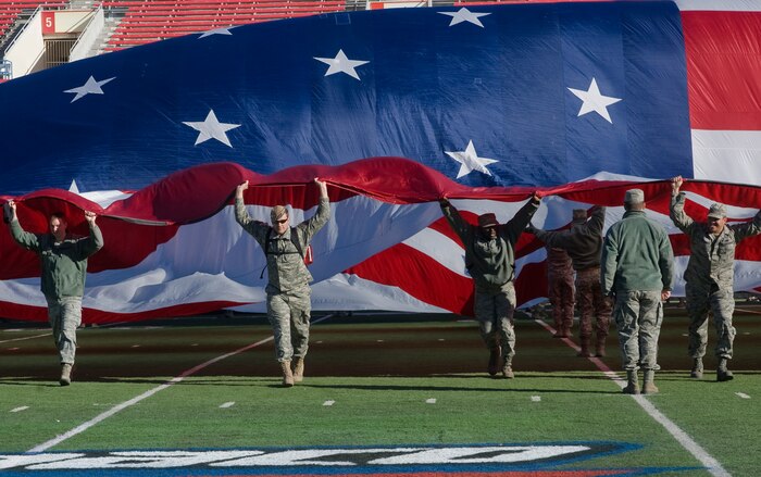 Nellis Air Force Base Airmen participated in the flag ceremony at the MAACO Bowl game Dec. 22, 2011, at Sam Boyd Stadium in Las Vegas, Nev. Approximately 200 service members volunteered to help display the football field-size flag for audience members watching the opening ceremony of the MAACO Bowl.  (U.S Air Force photo by Airman 1st Class Whiteny Jackson/Released) 