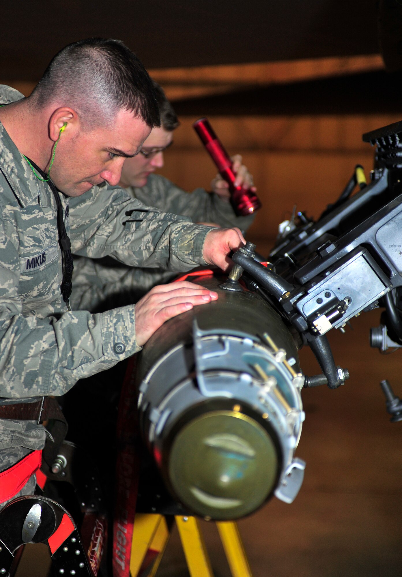 MINOT AIR FORCE BASE, N.D. – Tech. Sgt. Jamie Mikus and Staff Sgt. Jordan Ellis, 5th Maintenance Group weapons standardization evaluatorS, attach a GBU-38 GPS guided bomb to the heavy stores adapter beam of a B-52H Strattofortress, here Dec. 29. The weapons standardization section trains, evaluates and certifies personnel on munitions removal and installation on B-52s. (U.S. Air Force photo/Senior Airman Desiree Esposito)