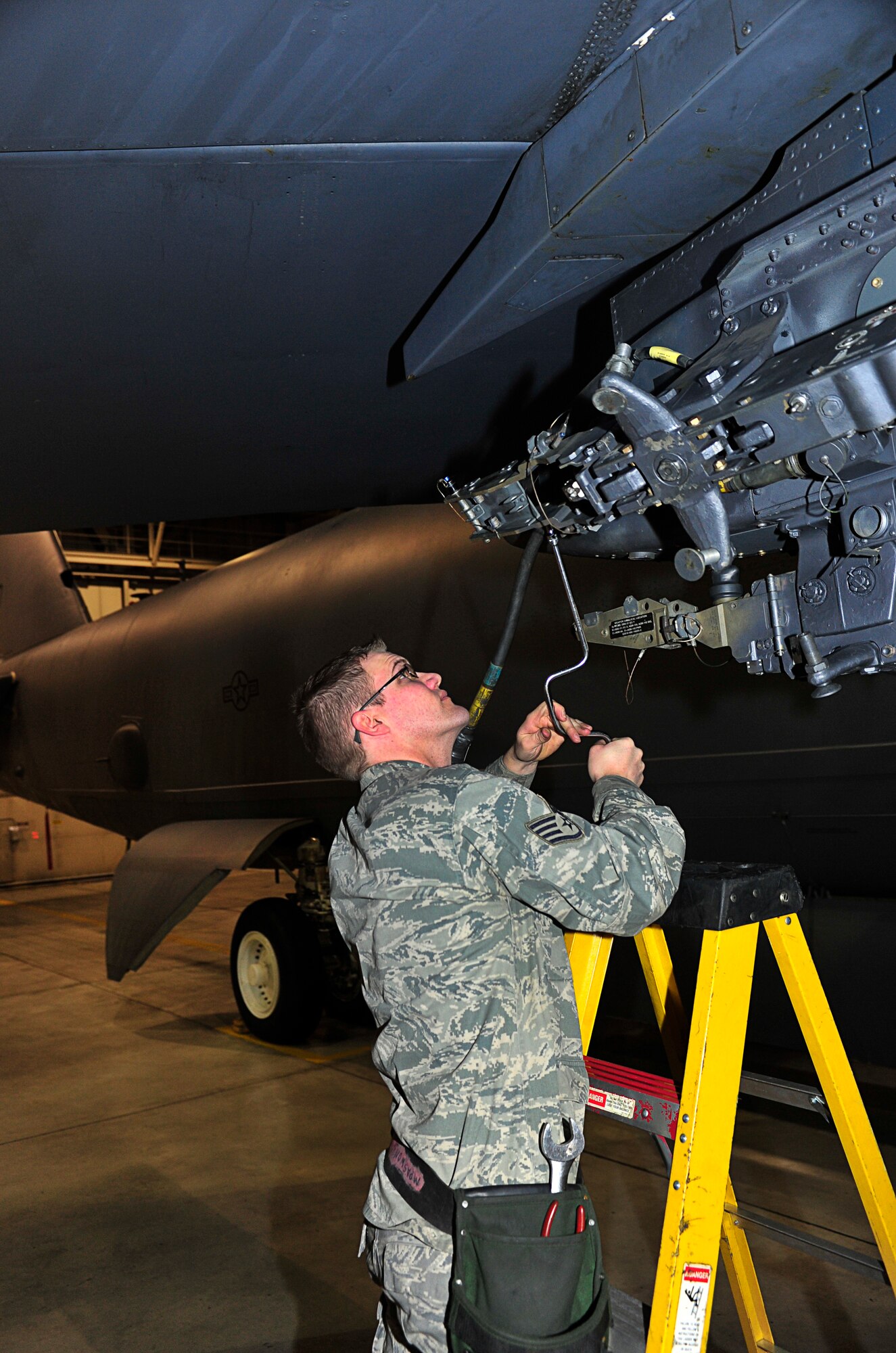 MINOT AIR FORCE BASE, N.D. – Staff Sgt. Jordan Ellis, 5th Maintenance Group weapons standardization evaluator, attaches a 1760 cable to the heavy stores adapter beam of a B-52H Stratofortress in preparation for a GBU-38 GPS guided bomb loading, here Dec. 29. The weapons standardization section trains, evaluates and certifies personnel on munitions removal and installation on B-52s. (U.S. Air Force Photo/Senior Airman Desiree Esposito)