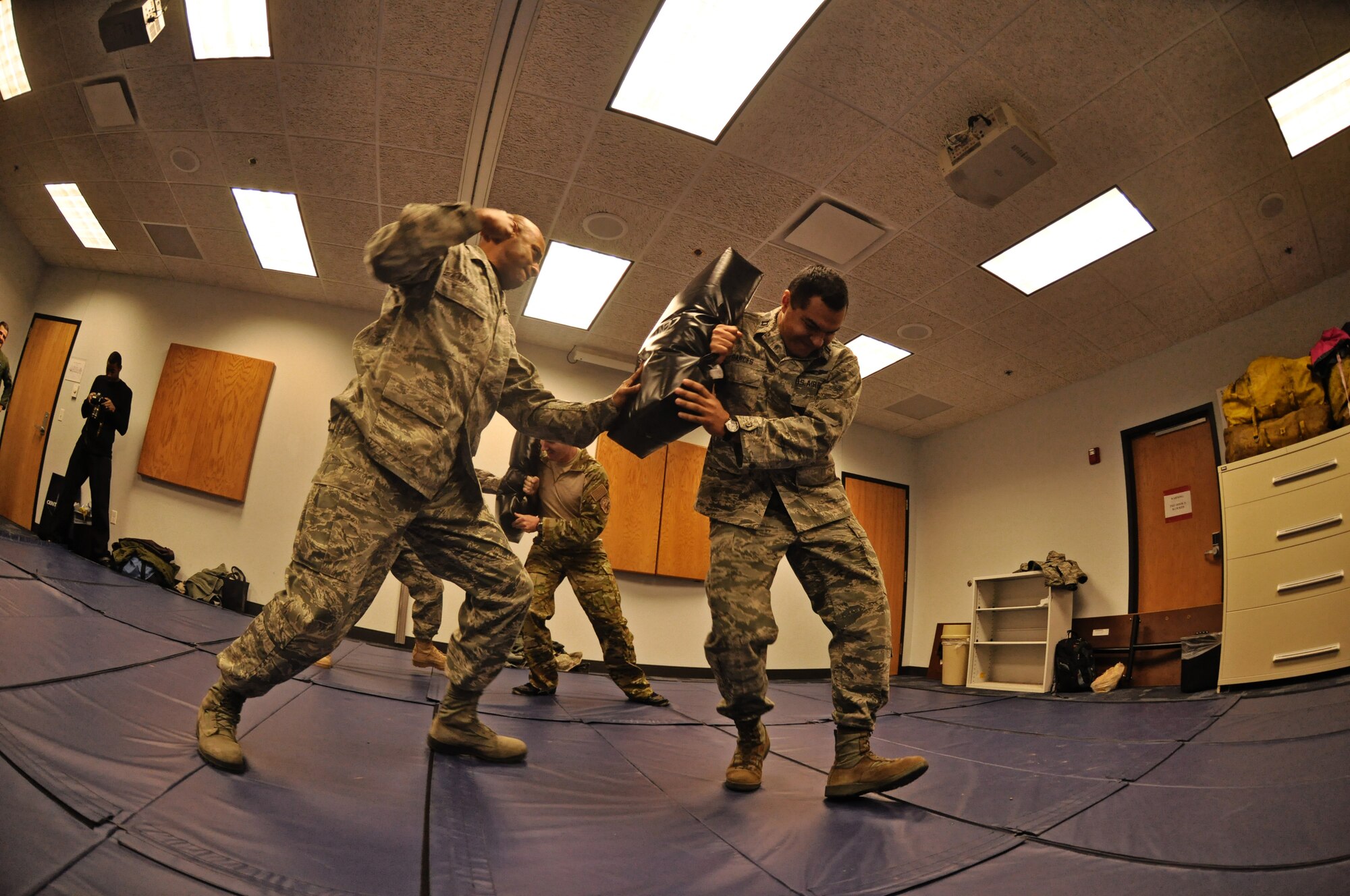 Senior Master Sgt. Rodney Lindsey, 375th Air Evacuation Squadron, practices striking his opponent, Capt. Luis Garces, 458th Airlift Squadron, while moving him backward during the combative portion of their survival, evasion, resistance, escape (SERE) training Dec. 13 at Scott Air Force Base, Ill. Aircrew members, and persons who have been deemed at risk of isolation are required to attend refresher SERE training every three years to make sure they are proficient with the techniques and skills that will keep them alive. (U.S. Air Force photo/ Staff Sgt. Ryan Crane)