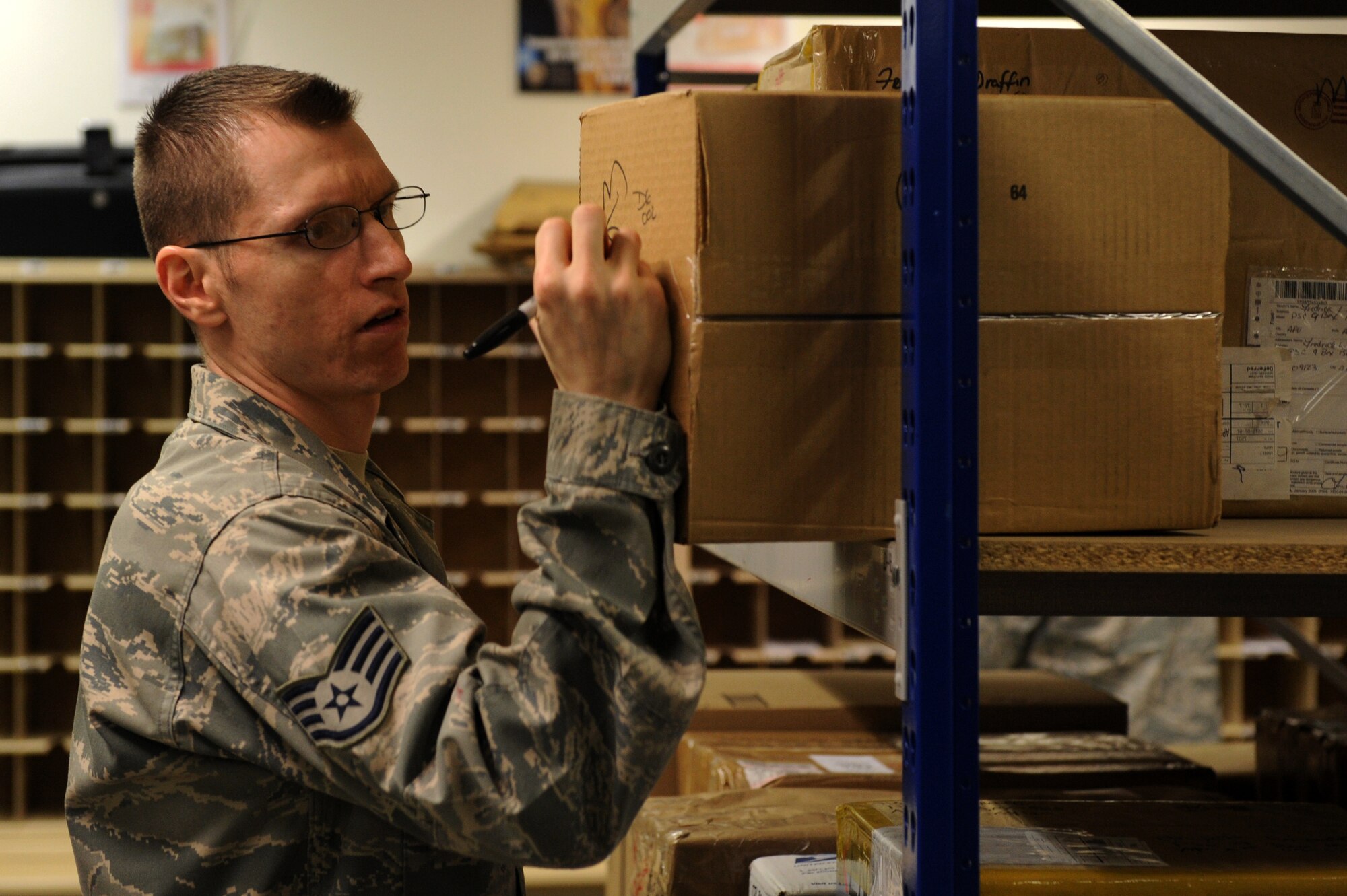 SPANGDAHLEM AIR BASE, Germany – Staff Sgt. Timothy Byrd, 52nd Communication Squadron postal clerk, marks a package with a P.O. Box number to be stored until picked up at the Spangdahlem Post Office here Jan. 2. The post office processed 423,000 pounds of inbound mail from Nov. 1 to Dec. 31 to ensure Saber Airmen and their families received their packages for the holiday season. (U.S. Air Force photo/Airman 1st Class Matthew B. Fredericks)