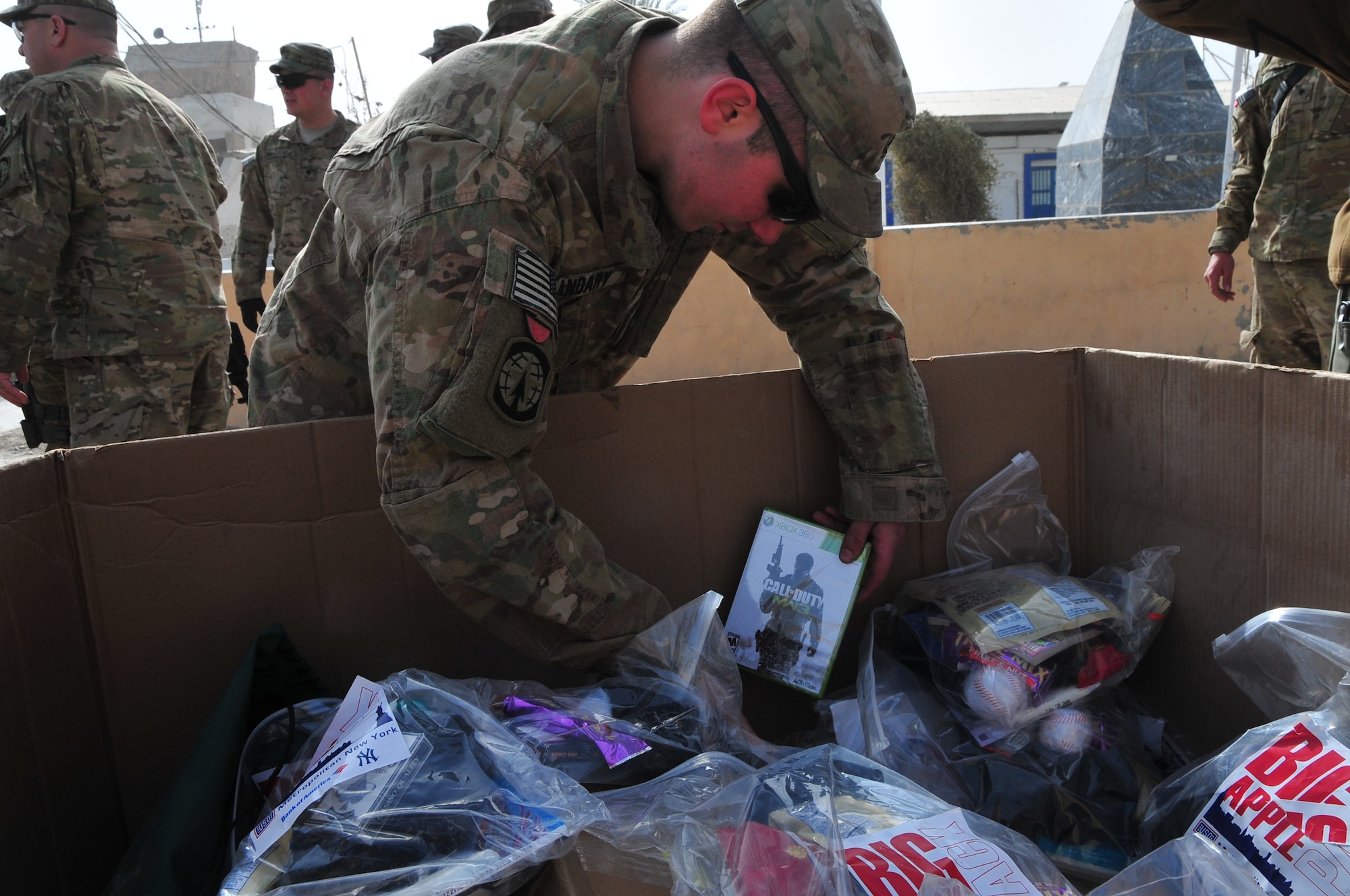 Pfc. Matthew Andary, a military policeman assigned to the 561st Military Police Company, pulls a copy of Call of Duty: Modern Warfare 3 from a USO donated gift box at Camp Nathan Smith, Dec. 23. The gifts were donated by the USO and delivered by Task Force Resolute during Operation Christmas Convoy. (U.S. Army photo by Staff Sgt. Alexander Burnett)