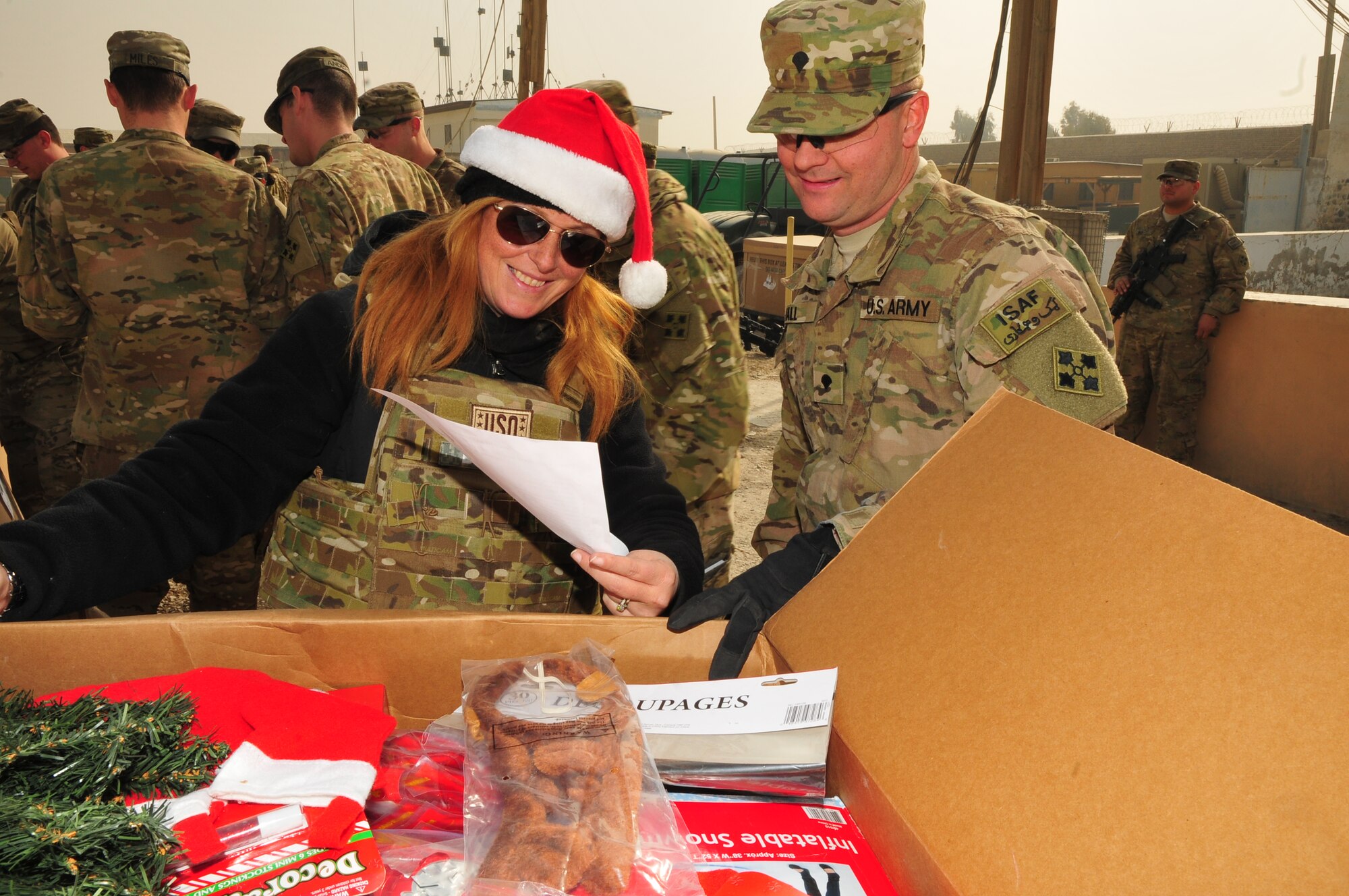Priya Butler, left, the USO director of operations for Southwest Asia, shows Spc. Torrence Hall, a cavalry scout assigned to Headquarters and Headquarters Troop, Task Force Bison, the holiday decorations for his unit donated by the USO during Operation Christmas Convoy at Camp Nathan Smith, Dec. 23. Operation Christmas Convoy delivered gifts to Soldiers on remote forward operating bases for the holiday season. (U.S. Army photo by Staff Sgt. Alexander Burnett)