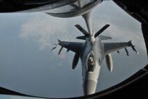 A KC-135 Stratotanker of the 909th Air Refueling Squadron from Kadena Air Base, Japan, refuels an F-16 Fighting Falcon during a training mission off the coast of the Republic of Korea, Dec. 28, 2011. As part of a joint effort between the 80th Fighter Squadron and the 909th ARS, military spouses visiting the area were given the opportunity to fly on the KC-135 during the aerial refueling. (U.S. Air Force photo by Senior Airman Brittany Y. Auld/Released)
