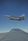 An F-16 Fighting Falcon coasts beside a KC-135 Stratotanker of the 909th Air Refueling Squadron from Kadena Air Base, Japan, as part of a refueling training mission off the coast of the Republic of Korea, Dec. 28, 2011. As part of a joint effort between the 80th Fighter Squadron and the 909th ARS, military spouses visiting the area were given the opportunity to fly on the KC-135 during the air refueling.  (U.S. Air Force photo by Senior Airman Brittany Y. Auld/Released)