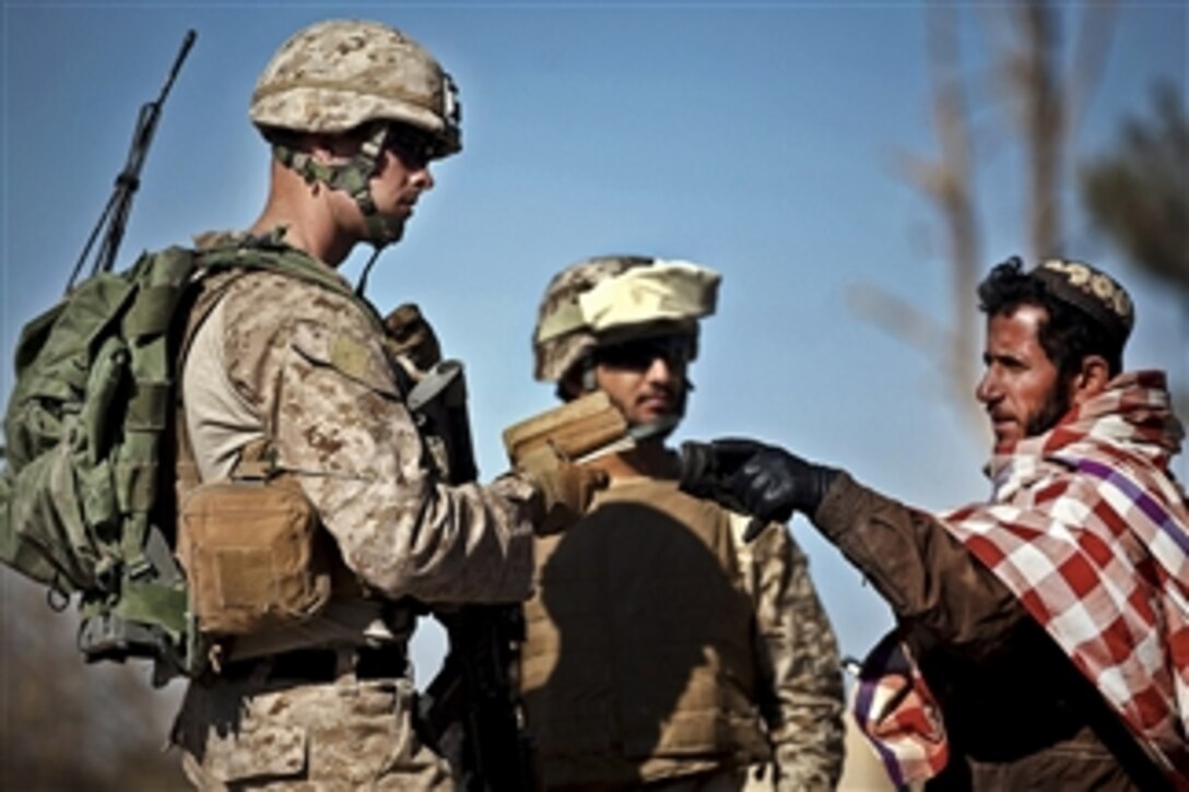 U.S. Marine Sgt. Matt Garst speaks with a local man about irrigation during a security patrol near a canal from which Marines previously helped rescue nine Afghans in Afghanistan's Helmand province on Dec. 12, 2011.  Garst is a squad leader assigned to 2nd Platoon, Lima Company, 3rd Battalion, 3rd Marine Regiment.  