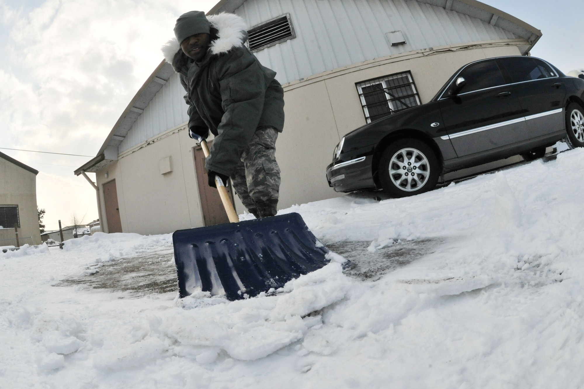 Staff Sgt. Rasheen Douglas, 8th Fighter Wing public affairs photography NCO in charge, shovels snow at Kunsan Air Base, Republic of Korea, Jan. 4, 2012. The Wolf Pack enjoyed their first snow day of the year. (U.S. Air Force photo by Senior Airman Brittany Y. Auld/Released)