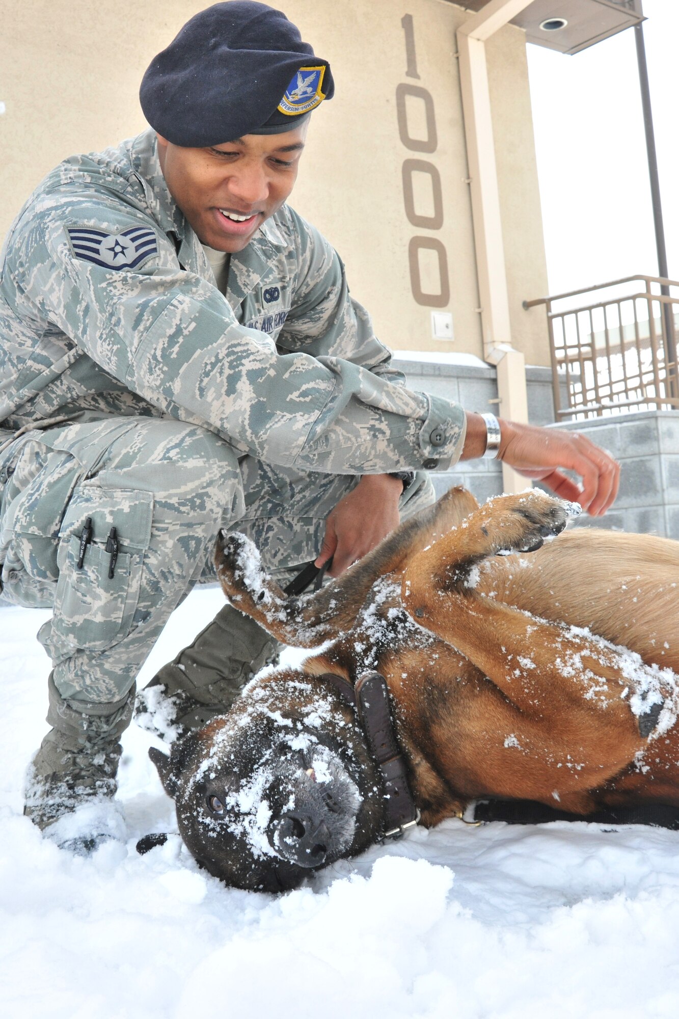 Staff Sgt. Mark Bush, 8th Security Forces Squadron military working dog handler, takes a break from validation training with Iian, 8th SFS military working dog, at Kunsan Air Base, Republic of Korea, Jan. 4, 2012. The Wolf Pack enjoyed their first snow day of the year. (U.S. Air Force photo by Senior Airman Brittany Y. Auld/Released)