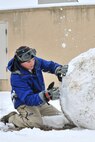 Senior Airman Jacob Chance, 8th Security Forces Squadron operations center controller, builds a snowman in front of his dormitory at Kunsan Air Base, Republic of Korea, Jan. 4, 2012. The Wolf Pack enjoyed their first snow day of the new year. (U.S. Air Force photo by Senior Airman Brittany Y. Auld/Released)